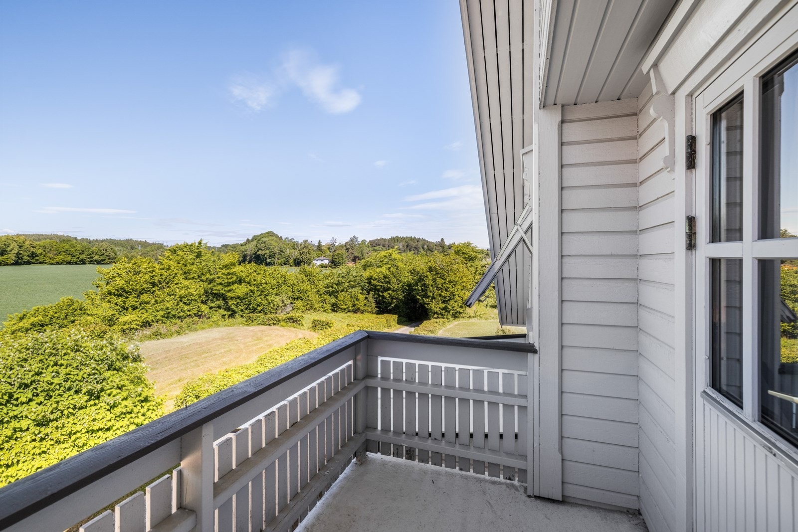 Fra loftstuen er det utgang til vestvendt balkong via tofløyet verandadør fra byggeår. Her er det flott utsyn over de landlige omgivelsene! Galleribilde