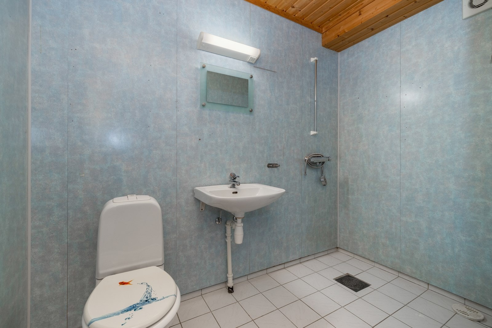 Badet i hovedetasjen er romslig og utstyrt med gulvvarme, toalett og vask, samt åpen dusjløsning. Galleribilde