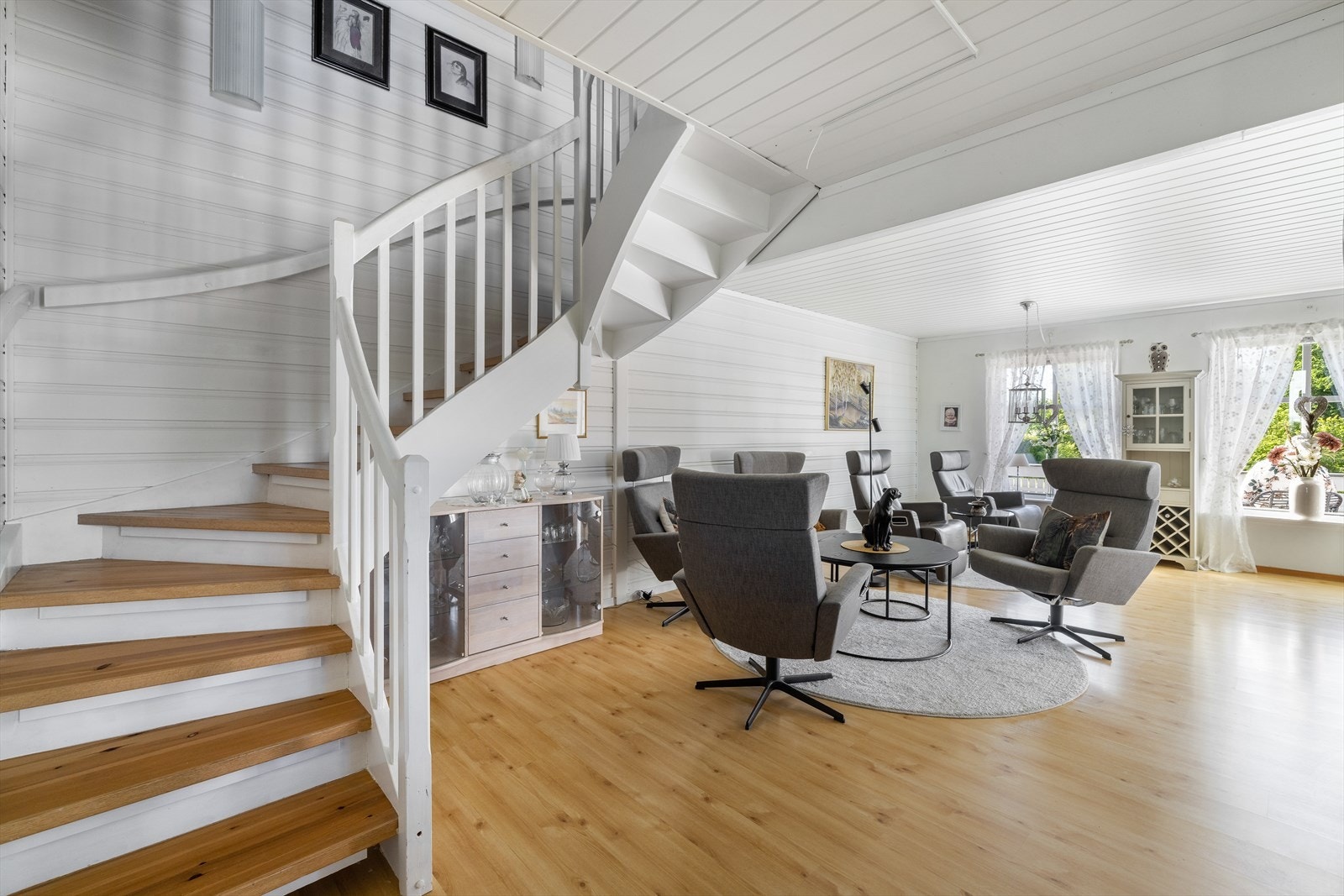 God plass til sofagruppe og annet stuemøblement. Stuen har uttak til sentralstøvsuger og oppgang til loftetasjen via tett, malt tretrapp med furutrinn. Galleribilde