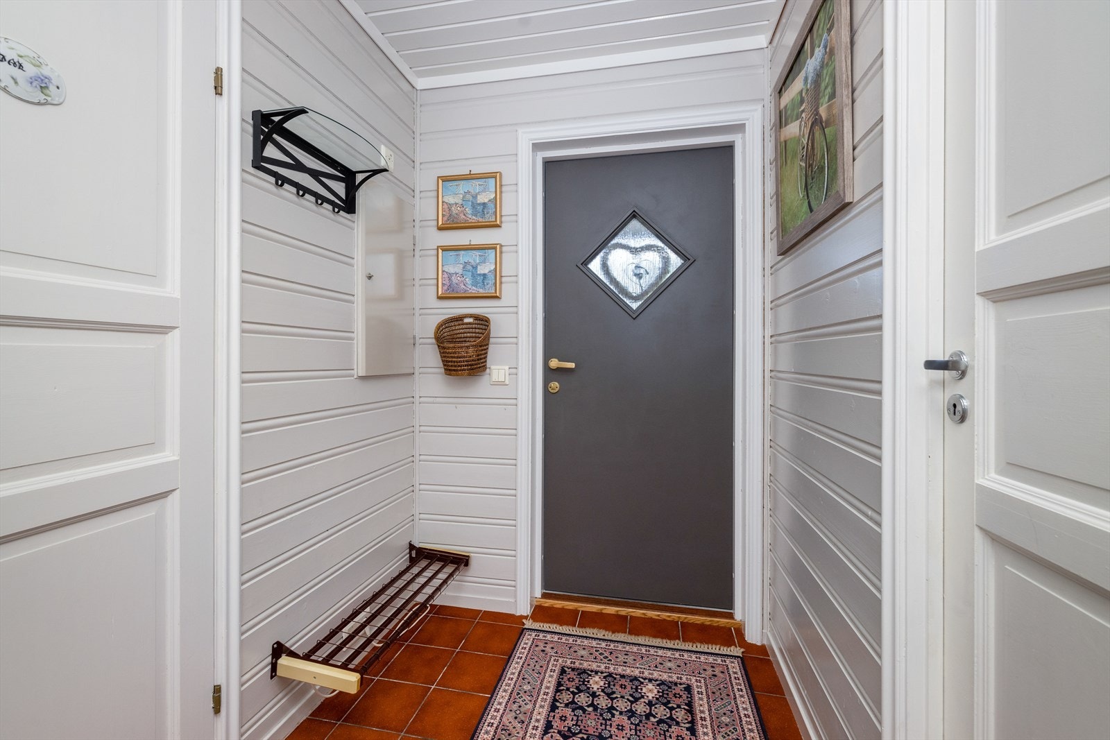 Lys entré med praktisk tilliggende vaskerom og toalettrom. Her er også boenhetens sikringsskap plassert, med automatsikringer hovedsakelig fra byggeår. Galleribilde