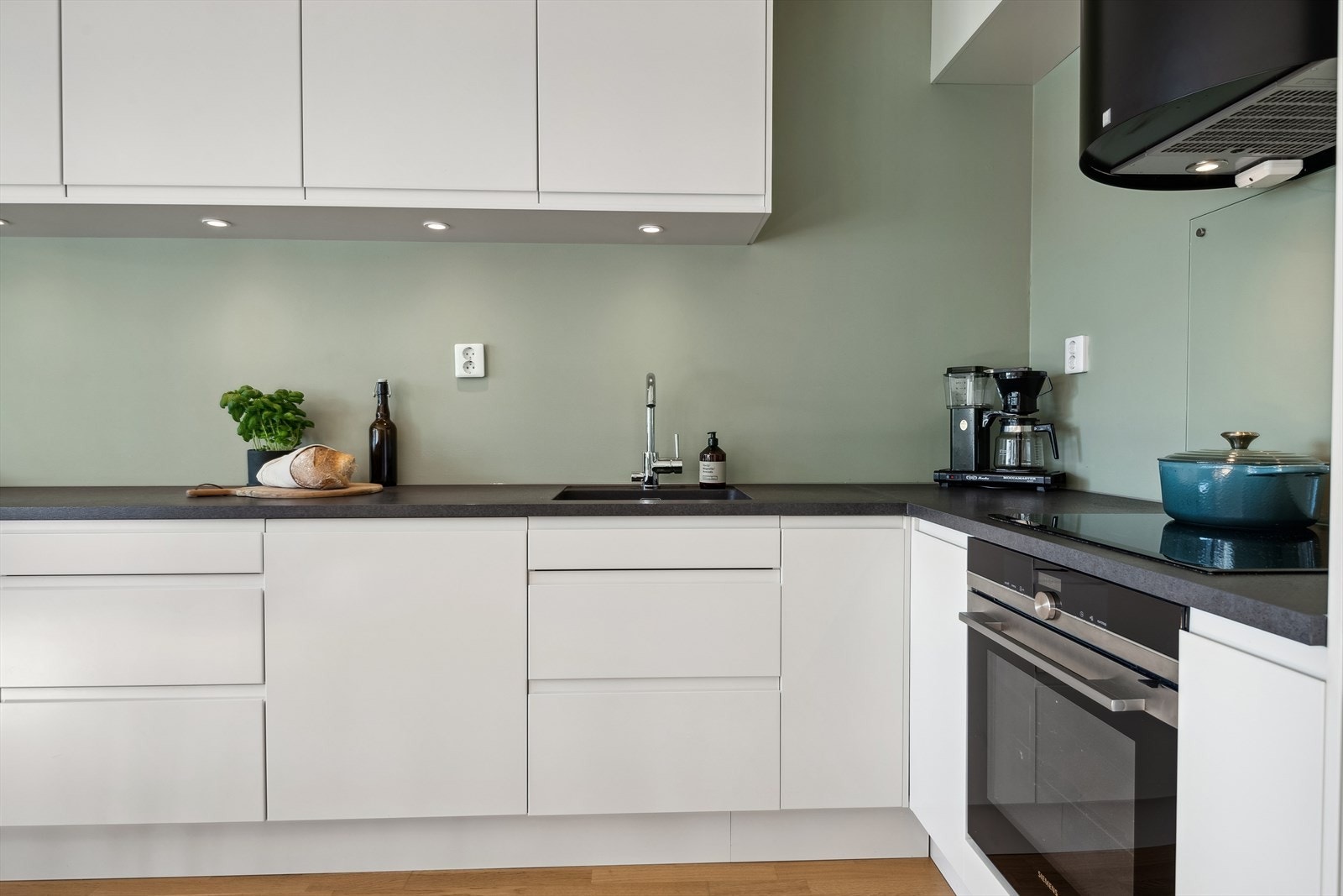 Innredning fra Sigdal (2017) med hvite, glatte fronter og benkeplater i laminat med underlimt oppvaskkum. Galleribilde