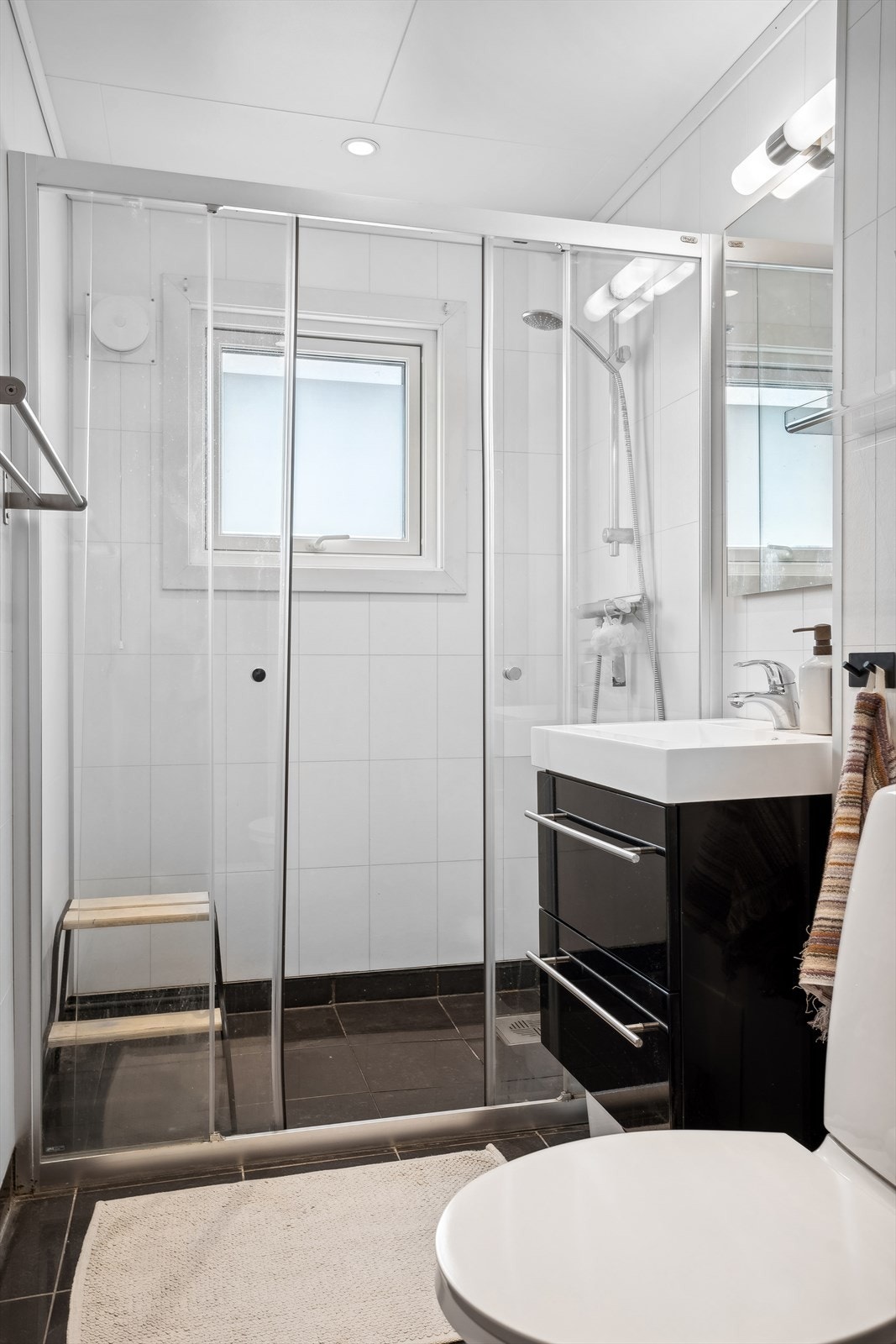 Baderommet har både belysning ved servant og spotter i tak Galleribilde