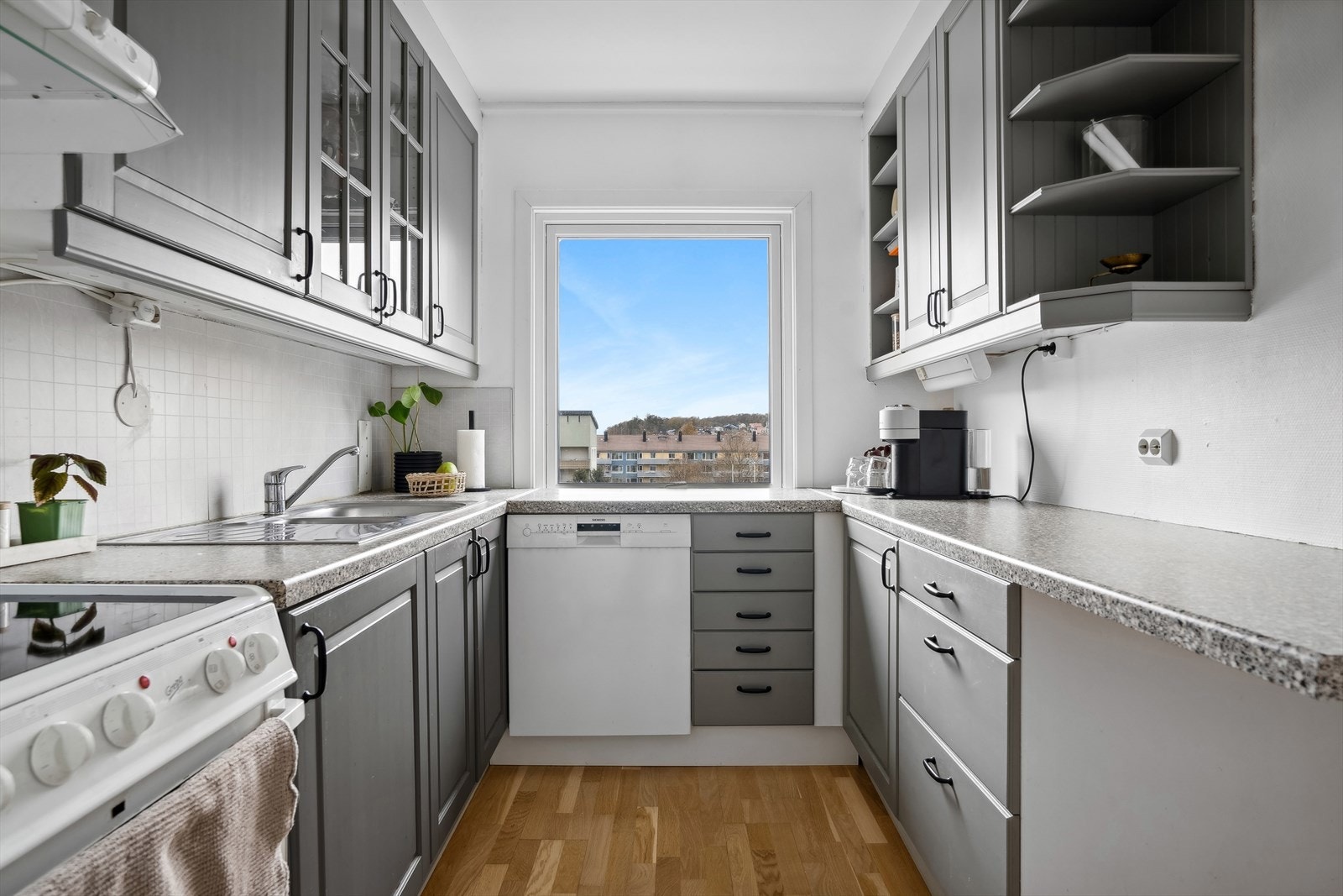 Kjøkkenet har innredning på to vegger med både over- og underskap på begge sidene Galleribilde