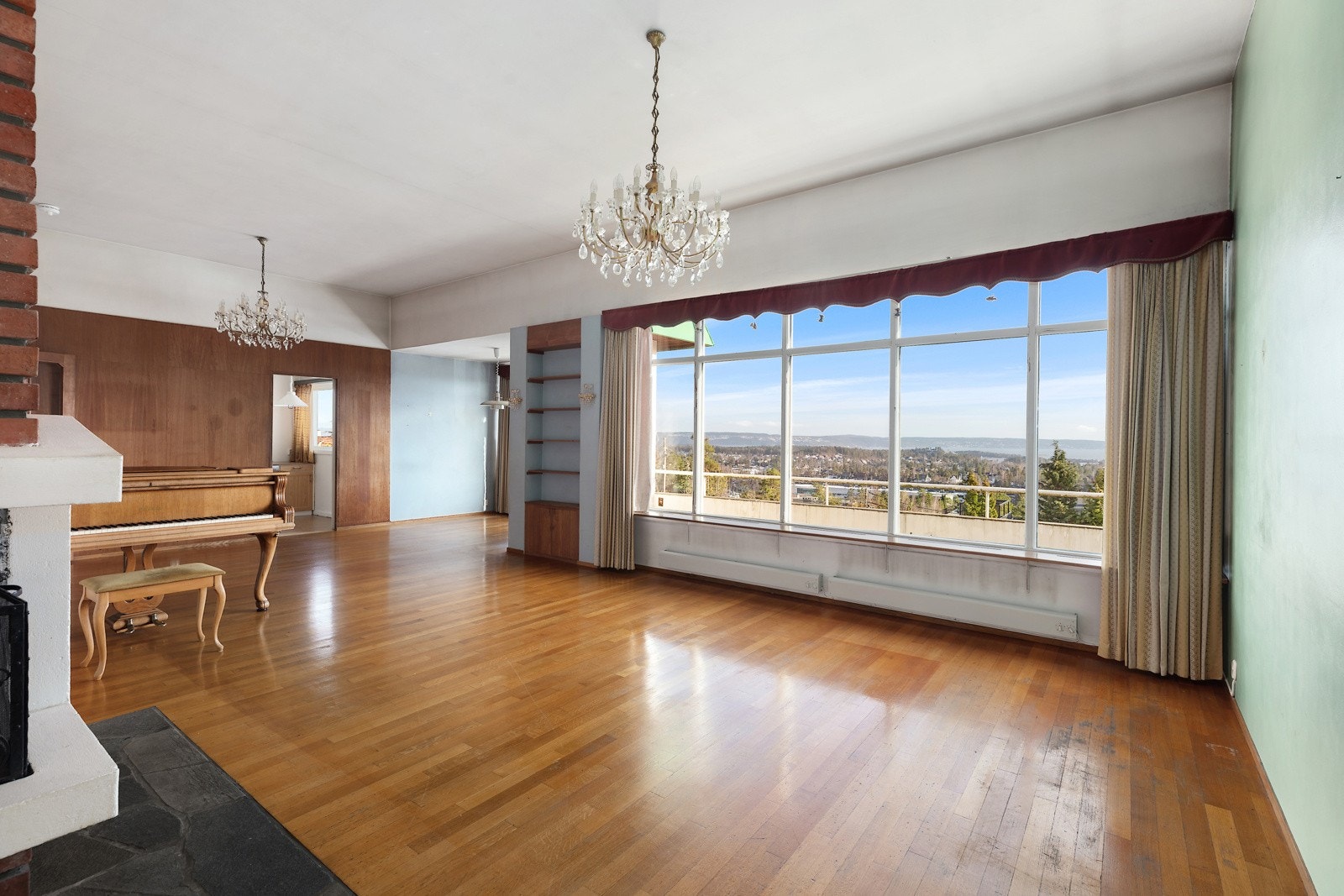 Romslig stue/spisestue med store vinduer mot syd og inngang til kjøkken Galleribilde