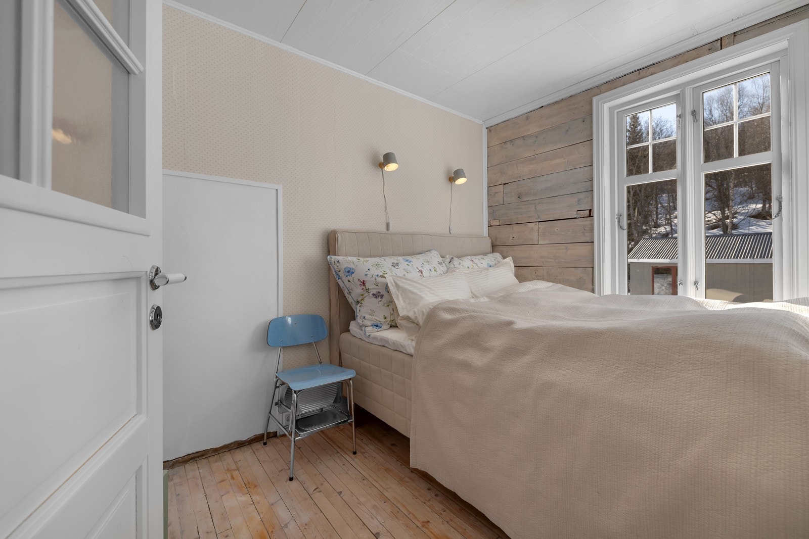 Lyst og trivelig soverom hvor den originale tømmerveggen er trukket frem Galleribilde