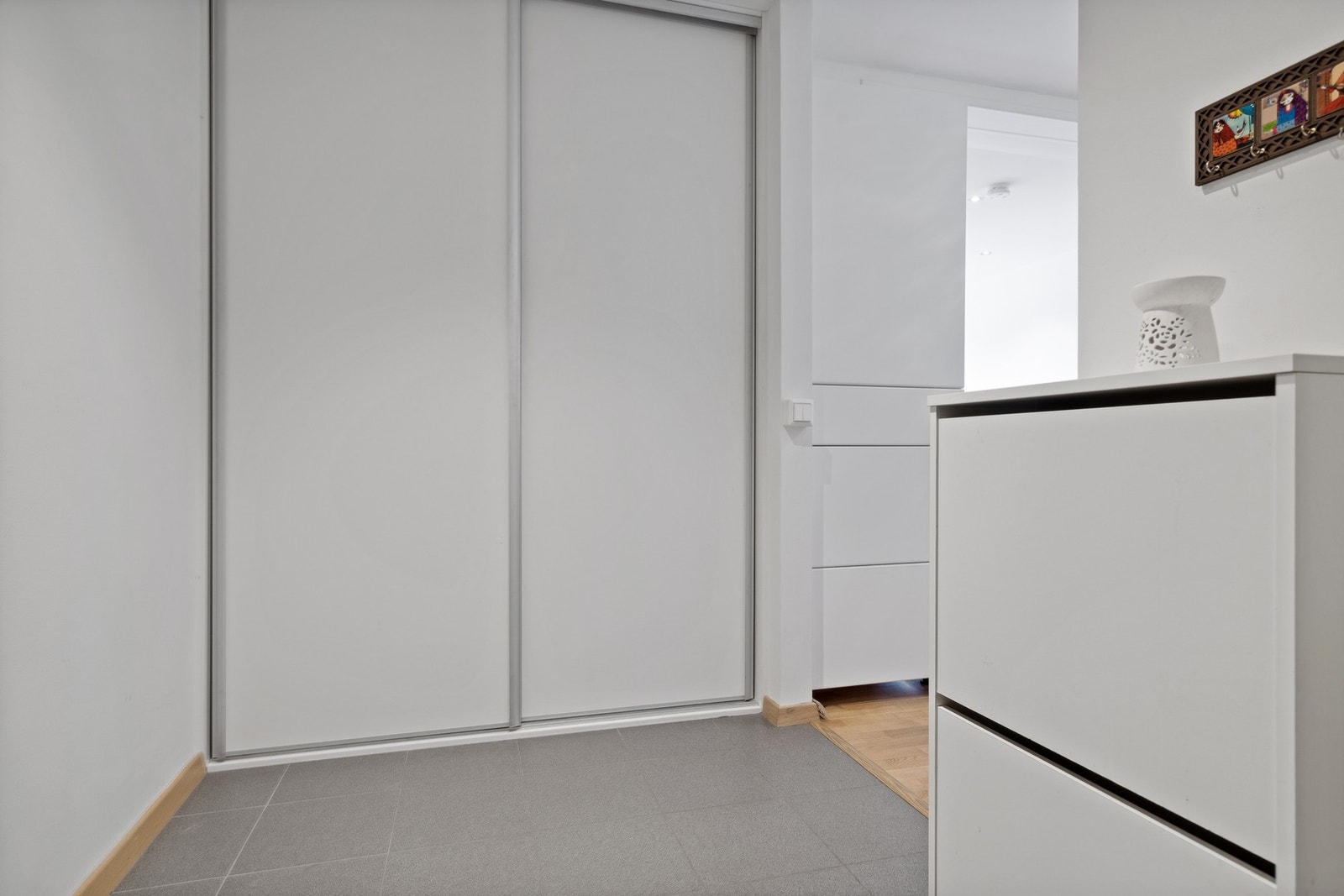 Romslig entré med plassbygd skyvedørsgarderobe. Galleribilde