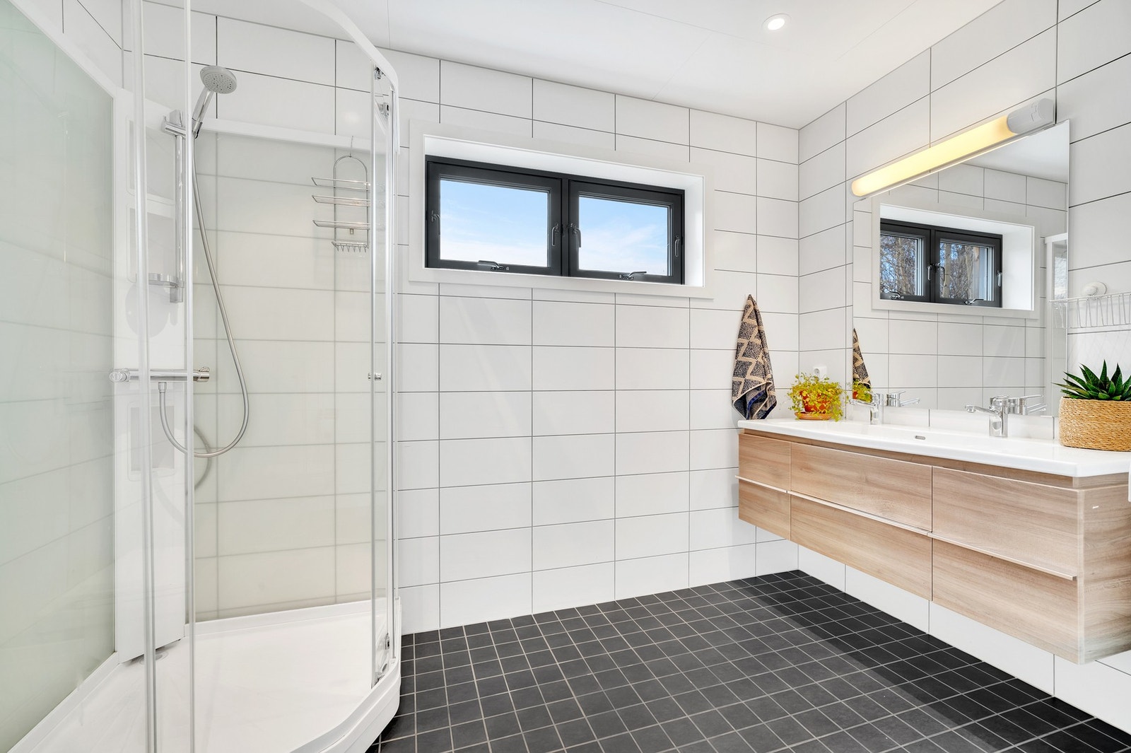 Flott bad i 1. etasje på nærmere 7 m² med oppgradert innredning m/dobbeltservant, dusjkabinett og veggmontert WC. Galleribilde