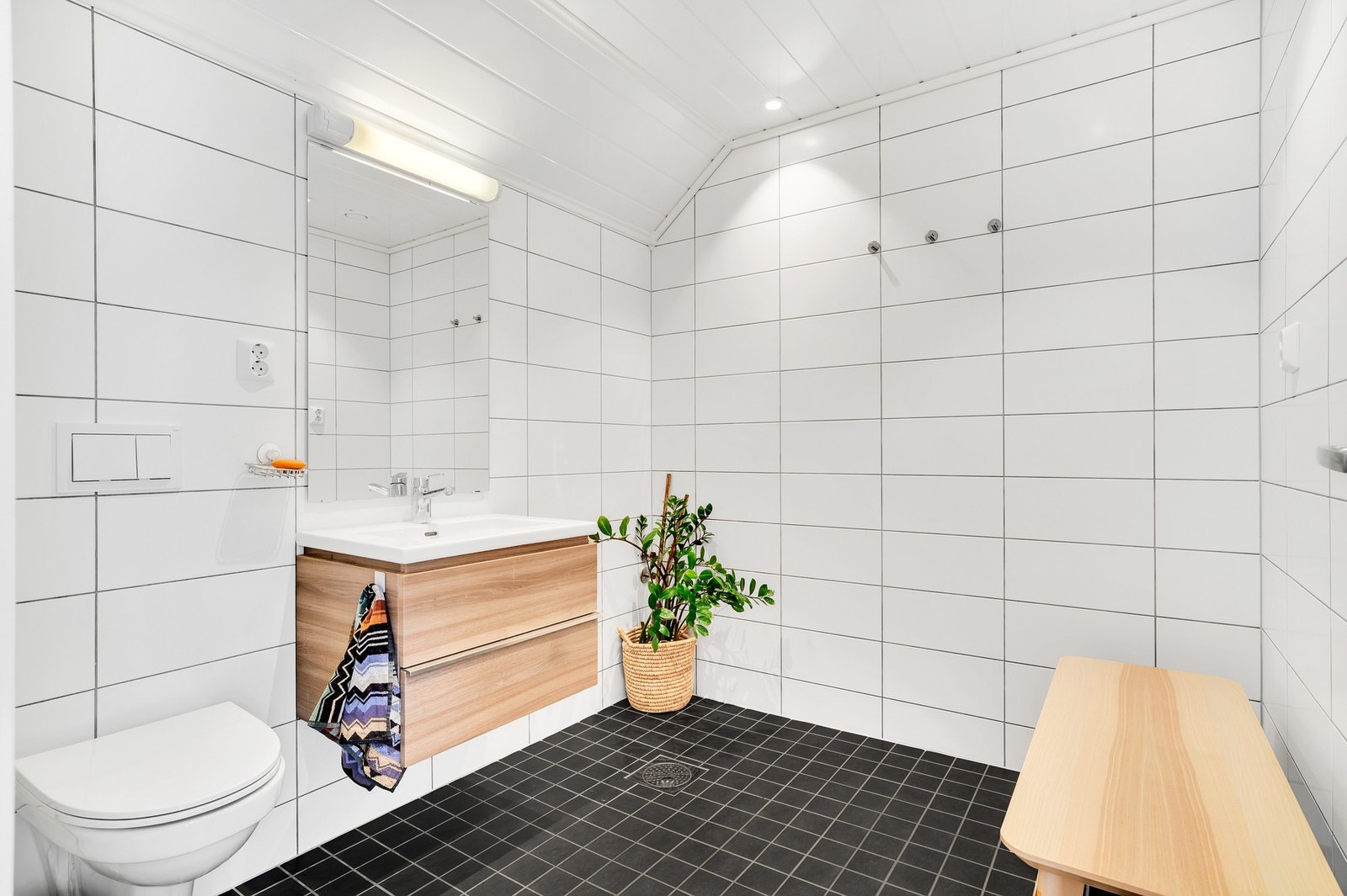 Lyst og flislagt bad i loftsetasjen på 5 kvm. Godt med lagringsplass i oppgradert innredning. Galleribilde