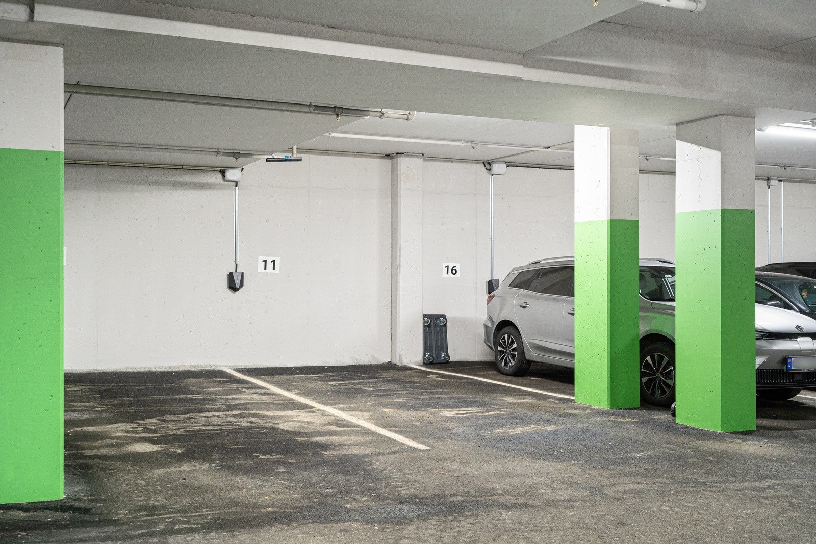 Parkeringsplass i oppvarmet parkeringskjeller med elbil-lader. Galleribilde