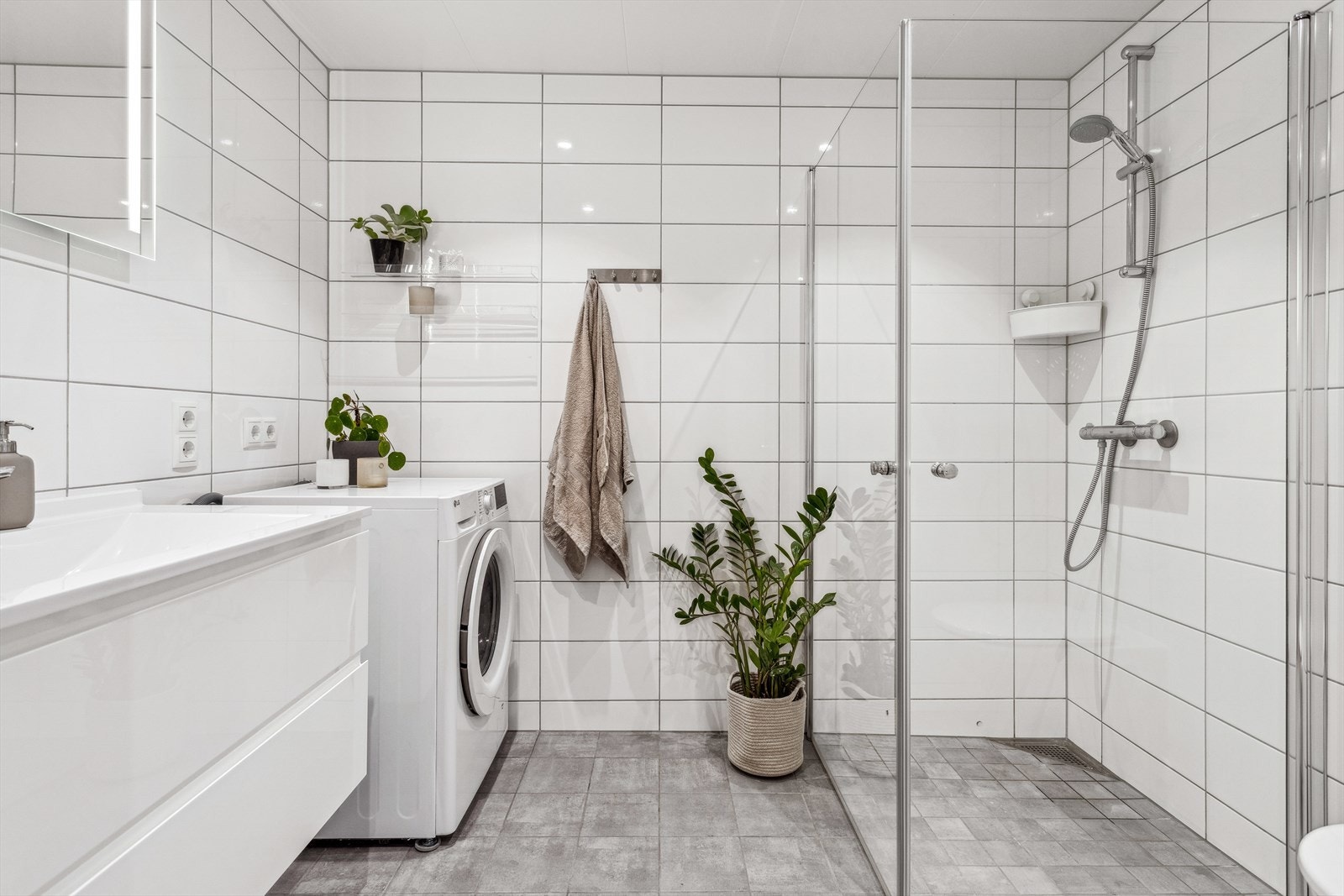 Flott flislagt bad med romslig dusjnisje og opplegg for vaskemaskin. Galleribilde