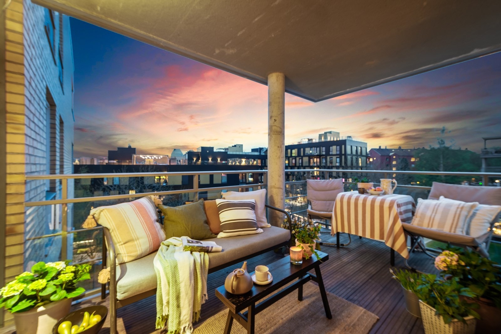 Solfylt balkong med plass til sittegruppe, grill og planter. Nedenfor balkongen er det en gangvei. Ingen biltrafikk Galleribilde