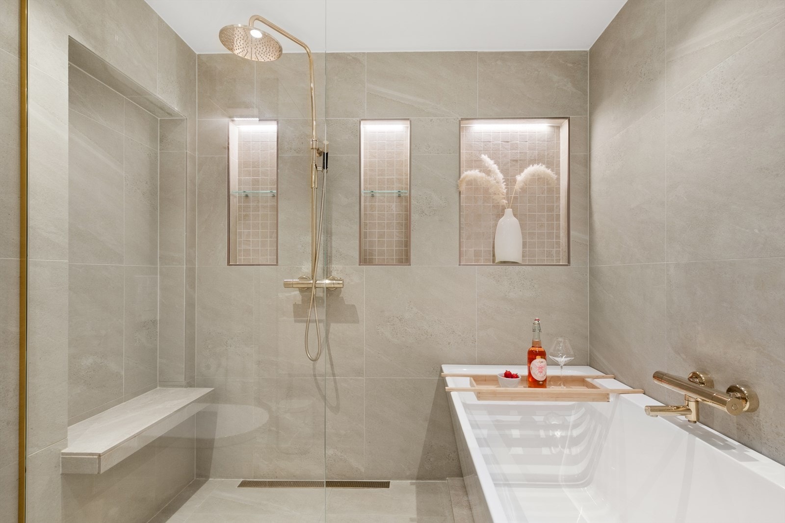 Badet er innredet med en stor dusj og badekar Galleribilde