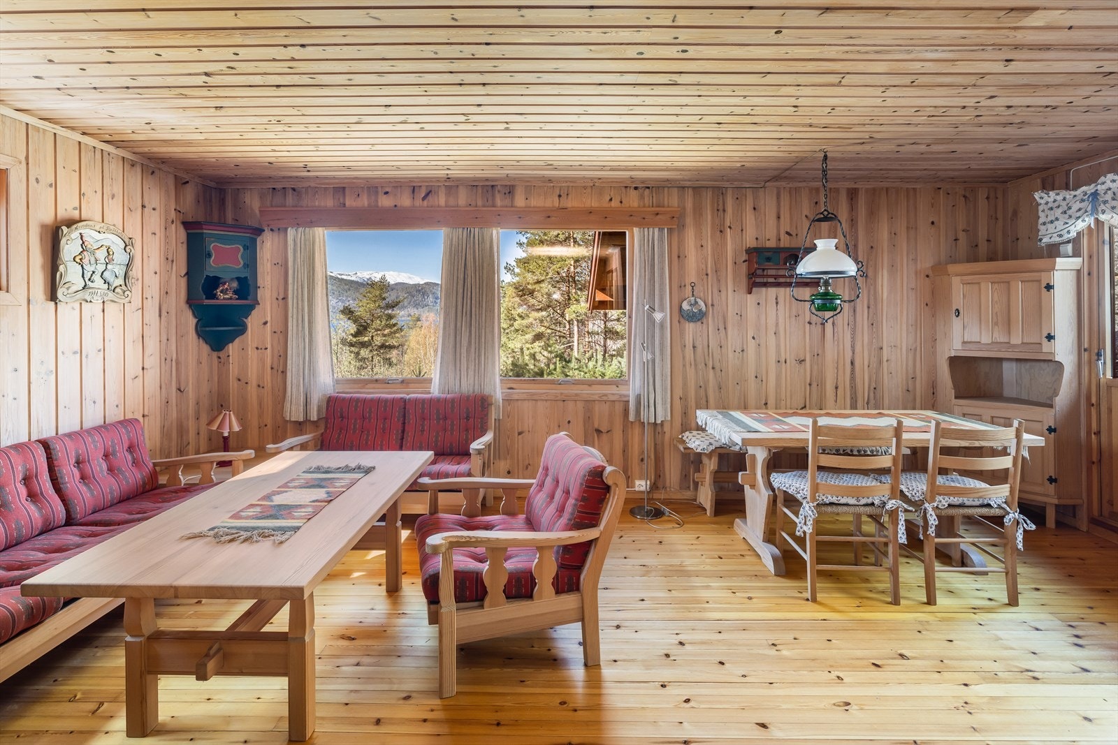 Hytta har en romslig og lys stue med peisovn og åpen kjøkkenløsning. Galleribilde