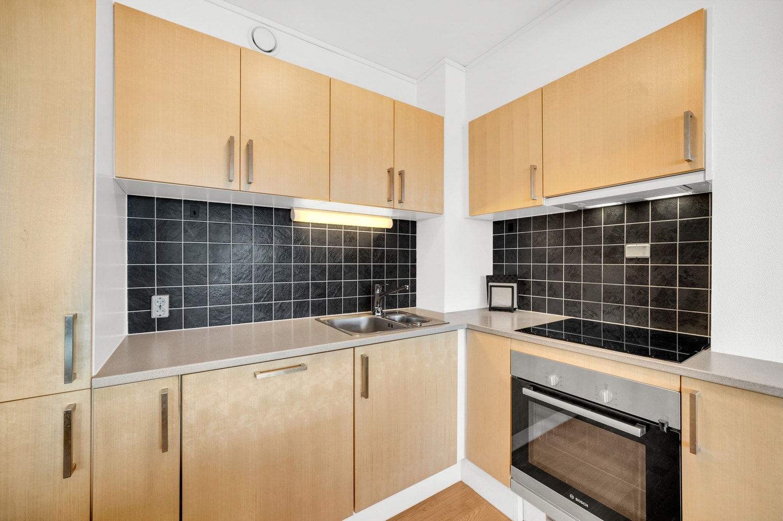 Pent kjøkken med mye skap- og benkeplass. Leiligheten har fått tilstandsgrad 1 (TG1) på tilnærmet alle punkter i takstmannens rapport. Galleribilde