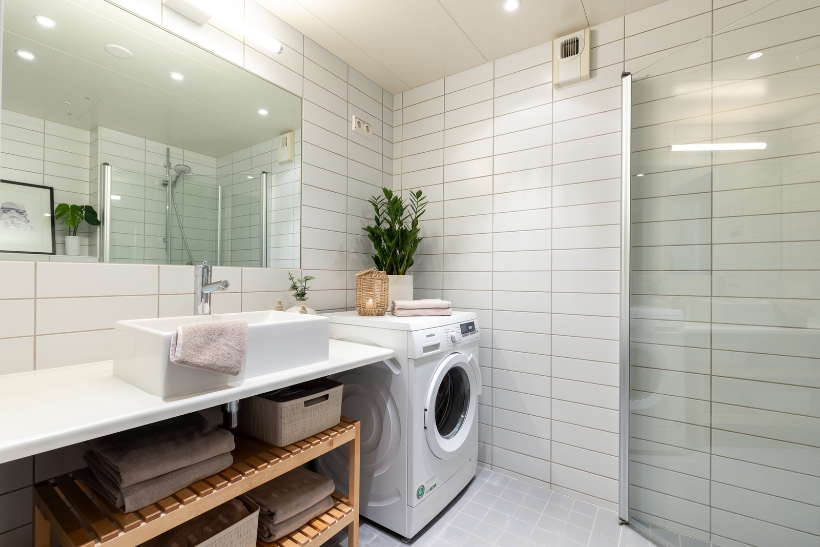 På badet er det hyller med påliggende servant, veggmontert toalett og dusjvegger/hjørne. Galleribilde