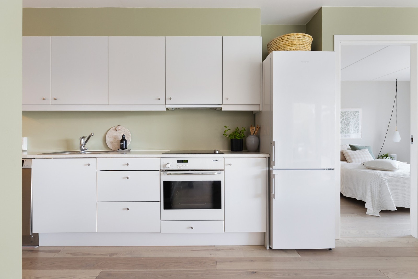 Flott kjøkkeninnredning med fabrikklakkerte glatte fronter og laminat benkeplate med nedfelt oppvaskkum og nedfelt koketopp. Galleribilde