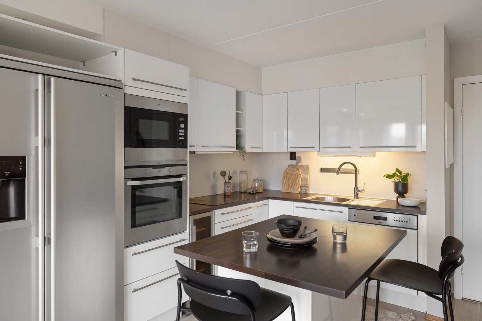 Kjøkkenet har en stilfull Norema innredning fra 2007 med hvite, høyglans laminerte fronter og laminerte benkeplater som gir et tidløst uttrykk Galleribilde