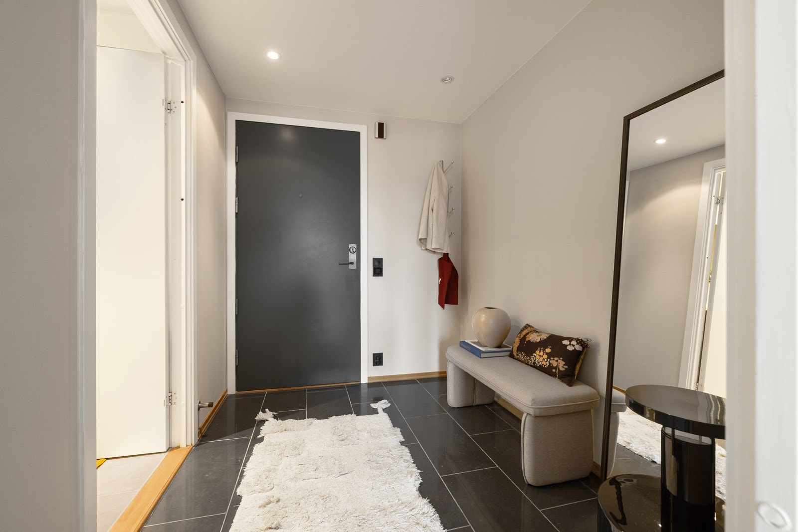 Innbydende entré som gir et godt førsteinntrykk av boligen. Gulvet er flislagt med behagelig gulvvarme. Her er det gode oppbevaringsmuligheter for yttertøy og sko. Callinganlegg med døråpner Galleribilde