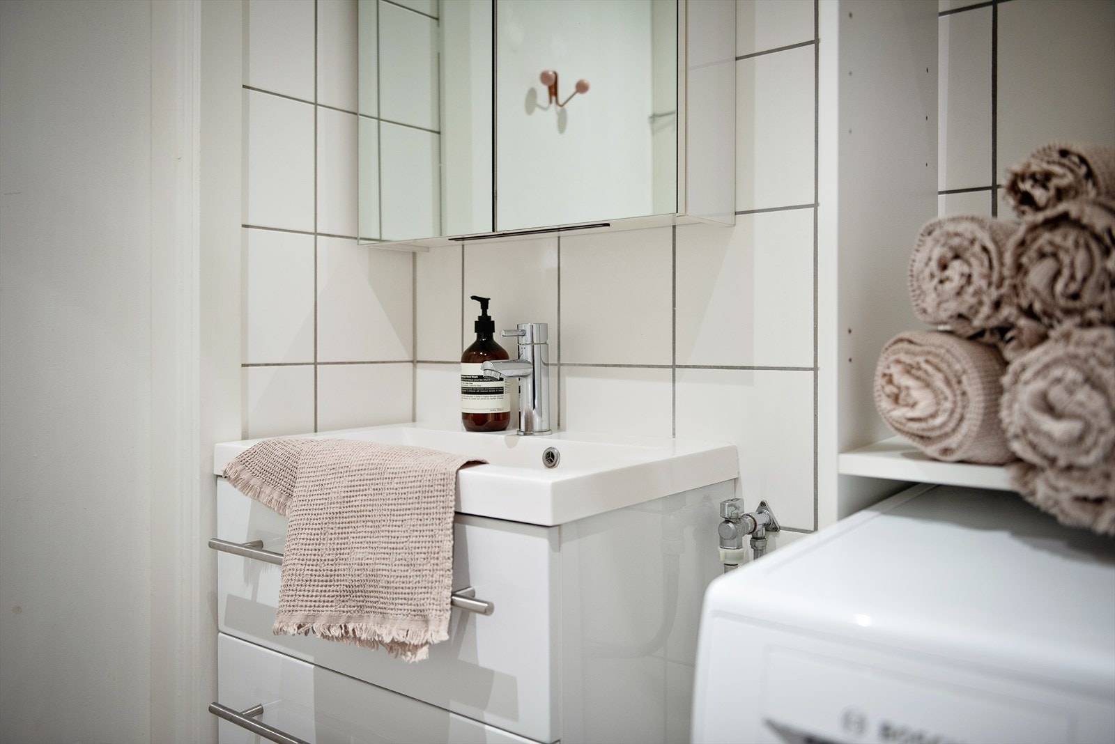 Baderomsinnredningen er fra 2018 og består av servantskap med høyglansfronter og heldekkende servant, speilskap, wc og dusjhjørne med forheng, sluk og dusjarmatur. Galleribilde