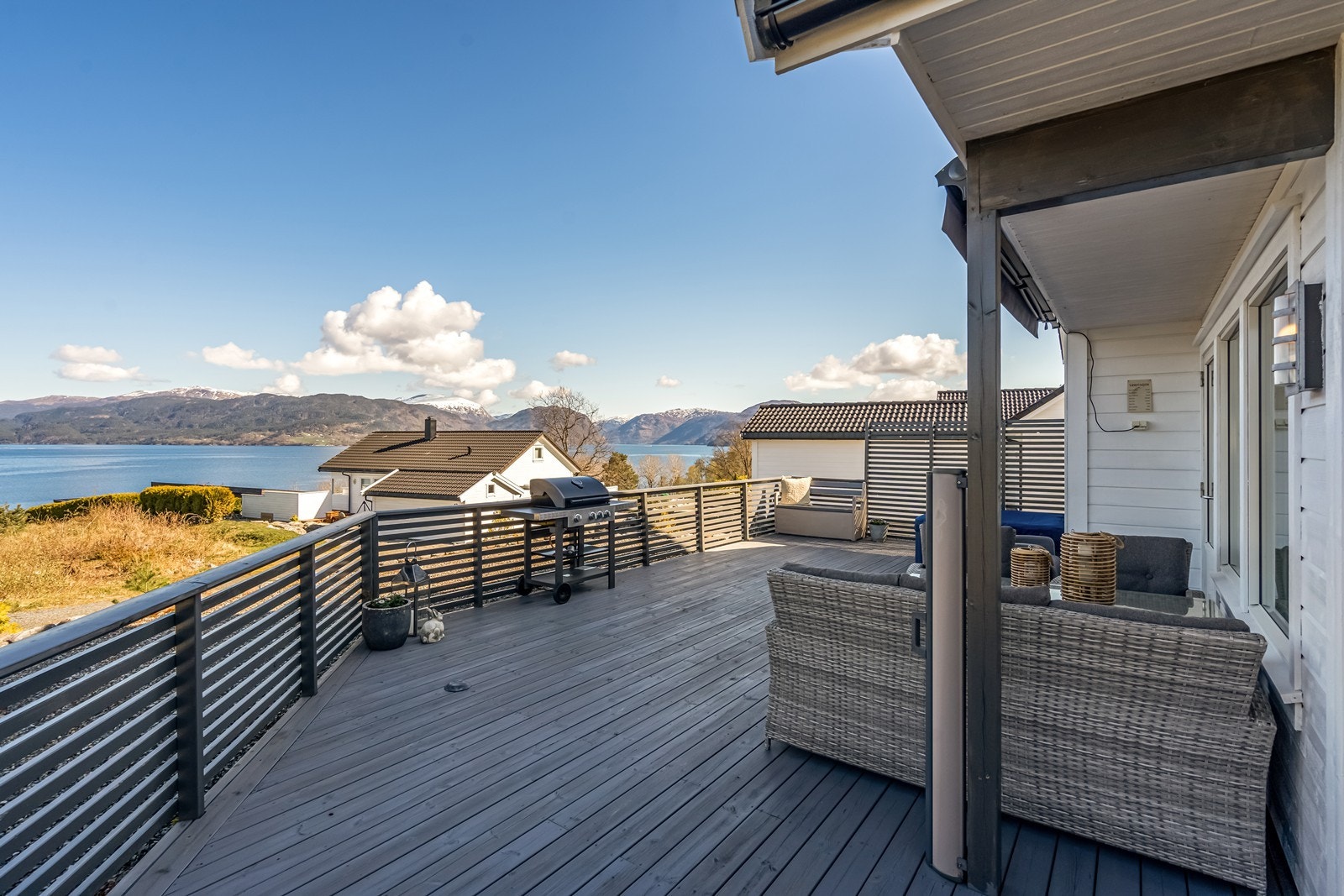 Stor terrasse med flere sittegrupper og spabad Galleribilde