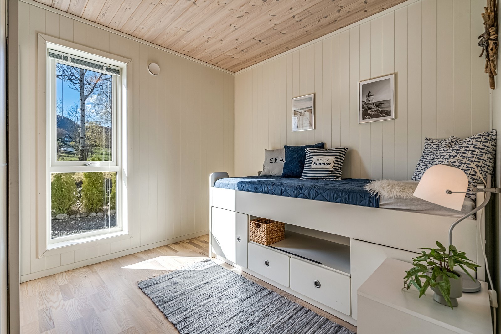 Soverom med skyvedørsgarderobe, persienner i vindu, seng med underskuffer og nattbord. Galleribilde