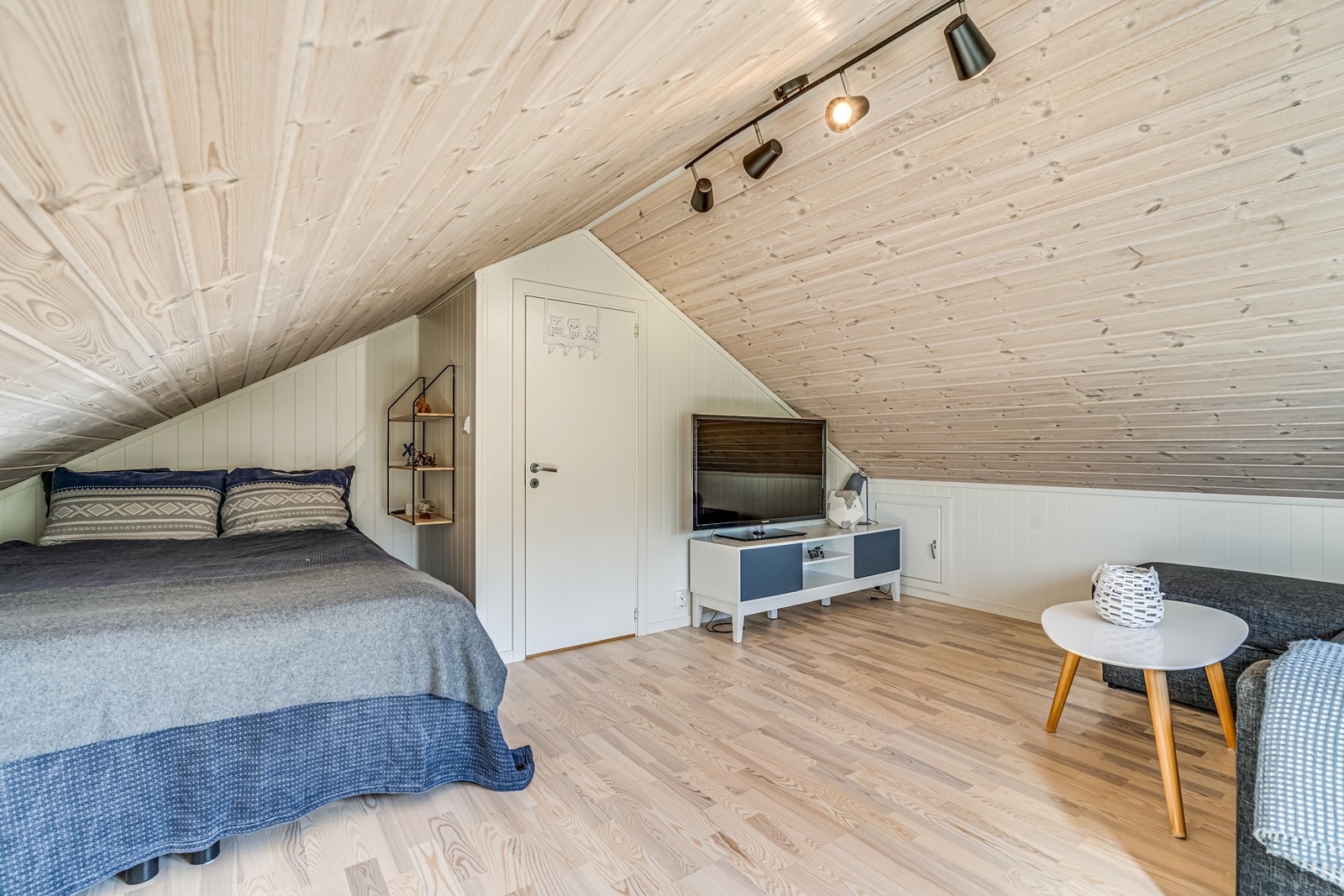 Loftstue / soverom med persienner i vindu, dobbeltseng, sofa (Denne kan også omgjøres til stor seng), TV, Tv benk, kommode. Galleribilde