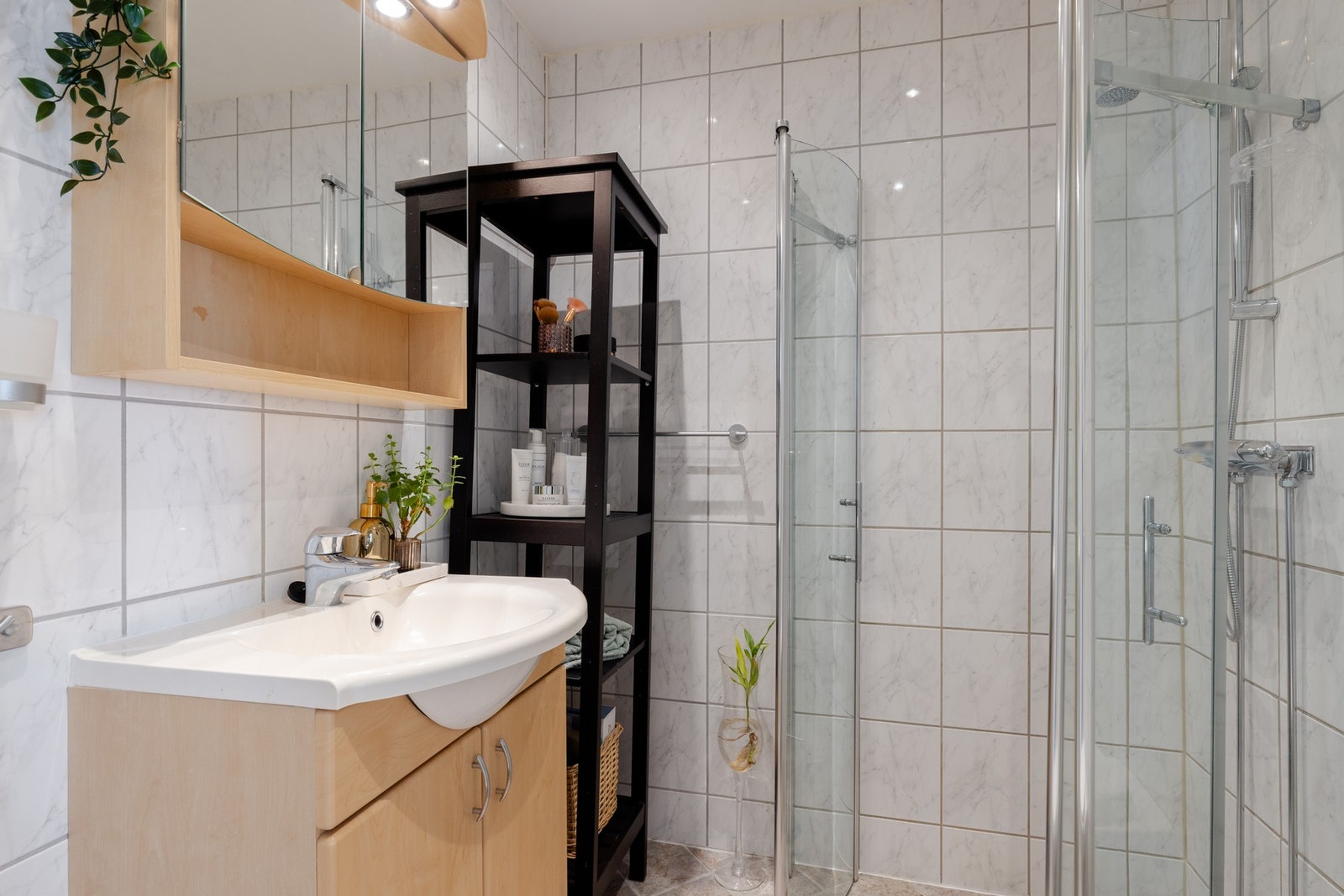 Badet er utstyrt med innredning med nedfelt servant, veggmontert toalett og dusjvegger/hjørne. Det er opplegg for vaskemaskin. Galleribilde