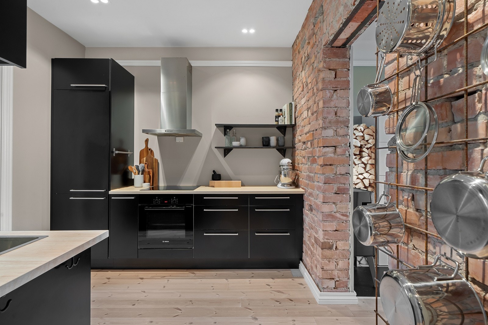 Innredningen fra Epoq fremstår som meget moderne med mørke slette fronter, stålhåndtak og overskap med benkeskapsbelysning Galleribilde