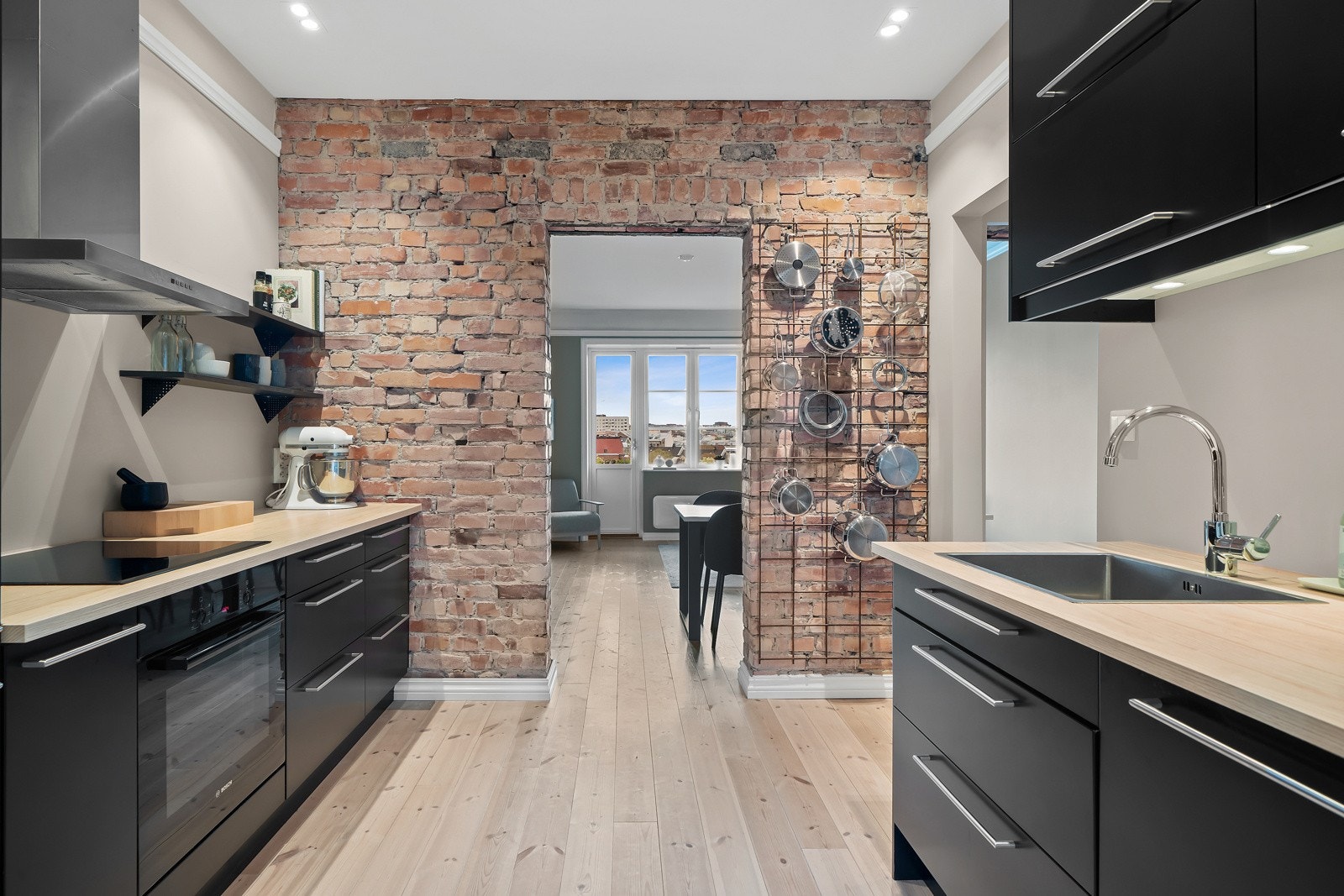 Kjøkkenet har integrerte hvitevarer som kjøl/frys, oppvaskmaskin, stekeovn samt platetopp fra Bosch og veggmontert avtrekksvifte Galleribilde