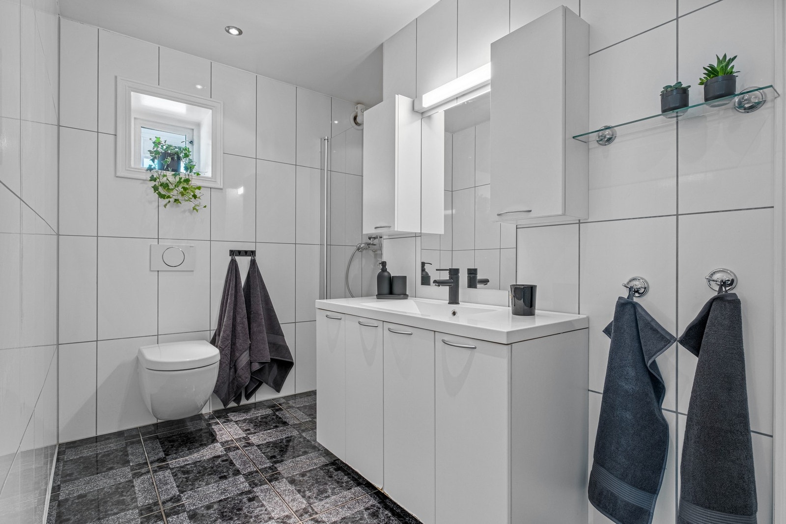Boligen har et pent flislagt bad i 1. etasje, i tillegg til badet i 2. etasje ved de andre soverommene i hoveddelen. Galleribilde