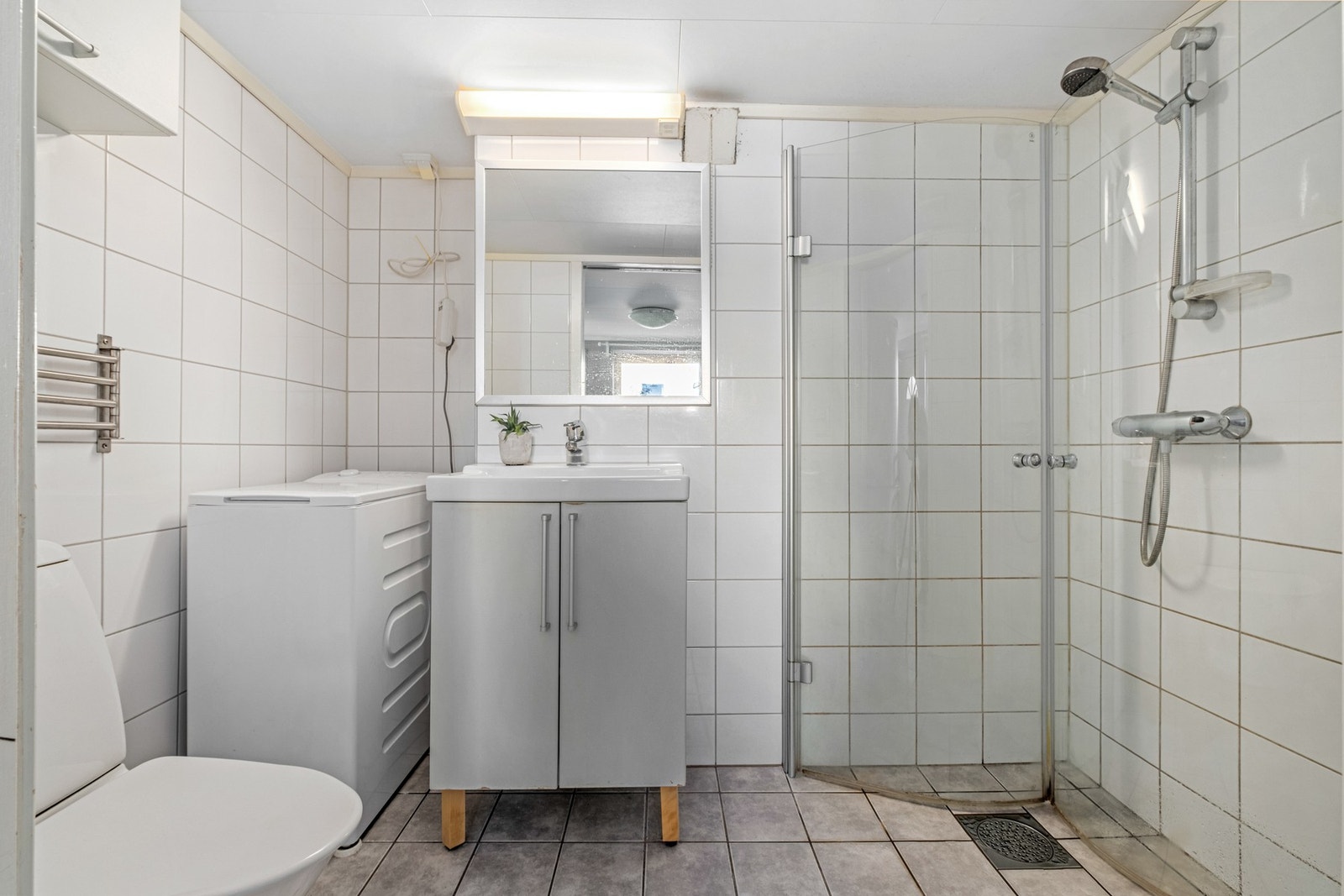 Pent flislagt bad med varmekabler i gulv. Vaskemaskin, medfølger i handelen. Galleribilde