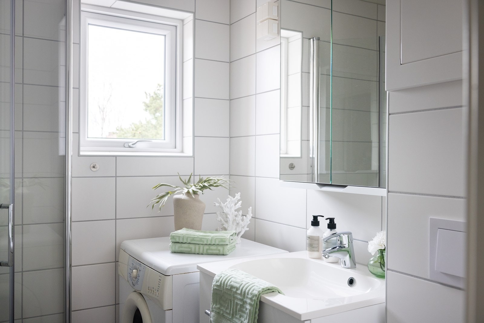 Pent flislagt baderom med innfelt downlights og elektrisk gulvvarme. Badet ble pusset opp i regi av borettslaget i 2021. Galleribilde