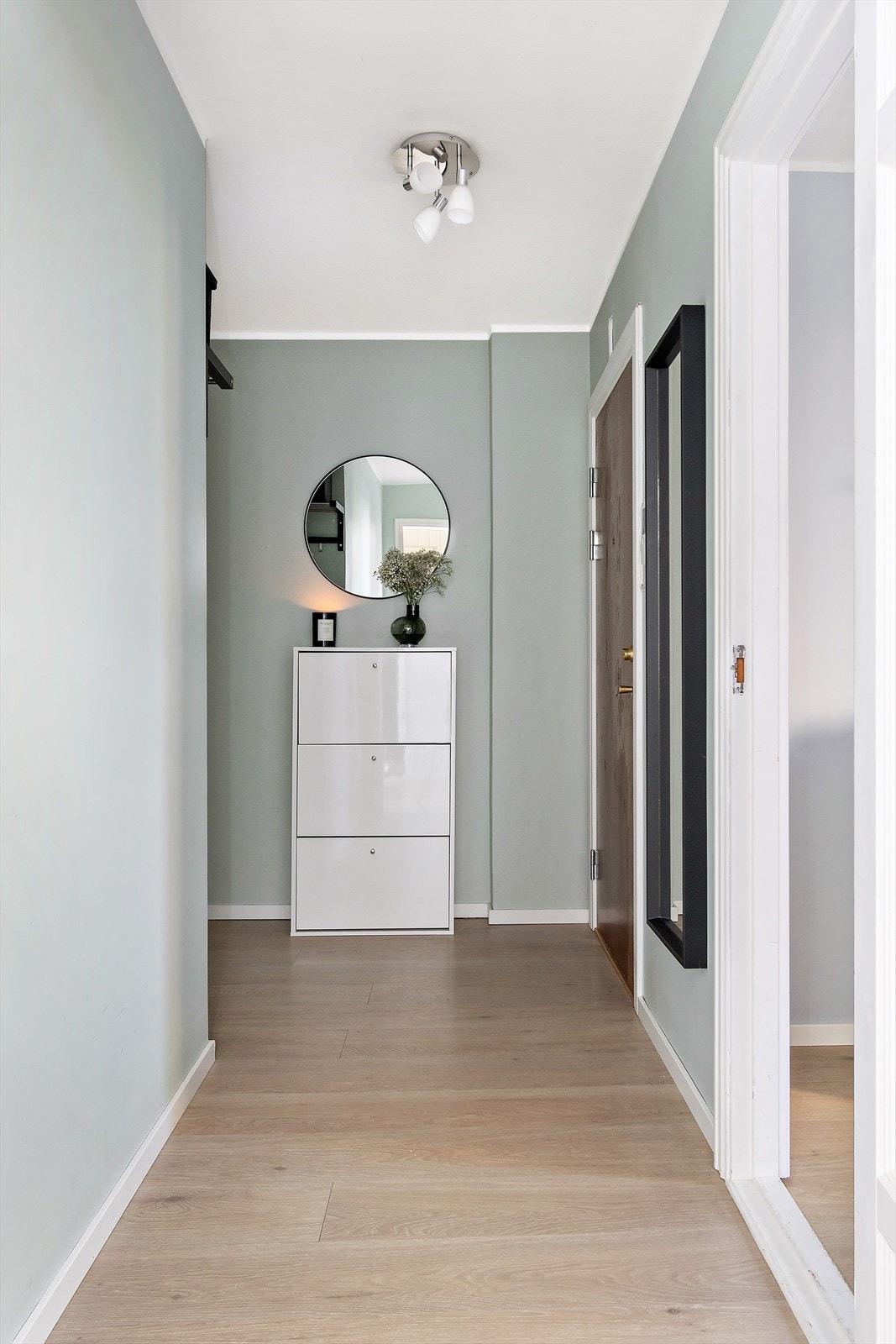 Innbyende entré malt i delikate farger med laminat gulv. Her er det god oppbevaringsplass til yttertøy og sko. Galleribilde