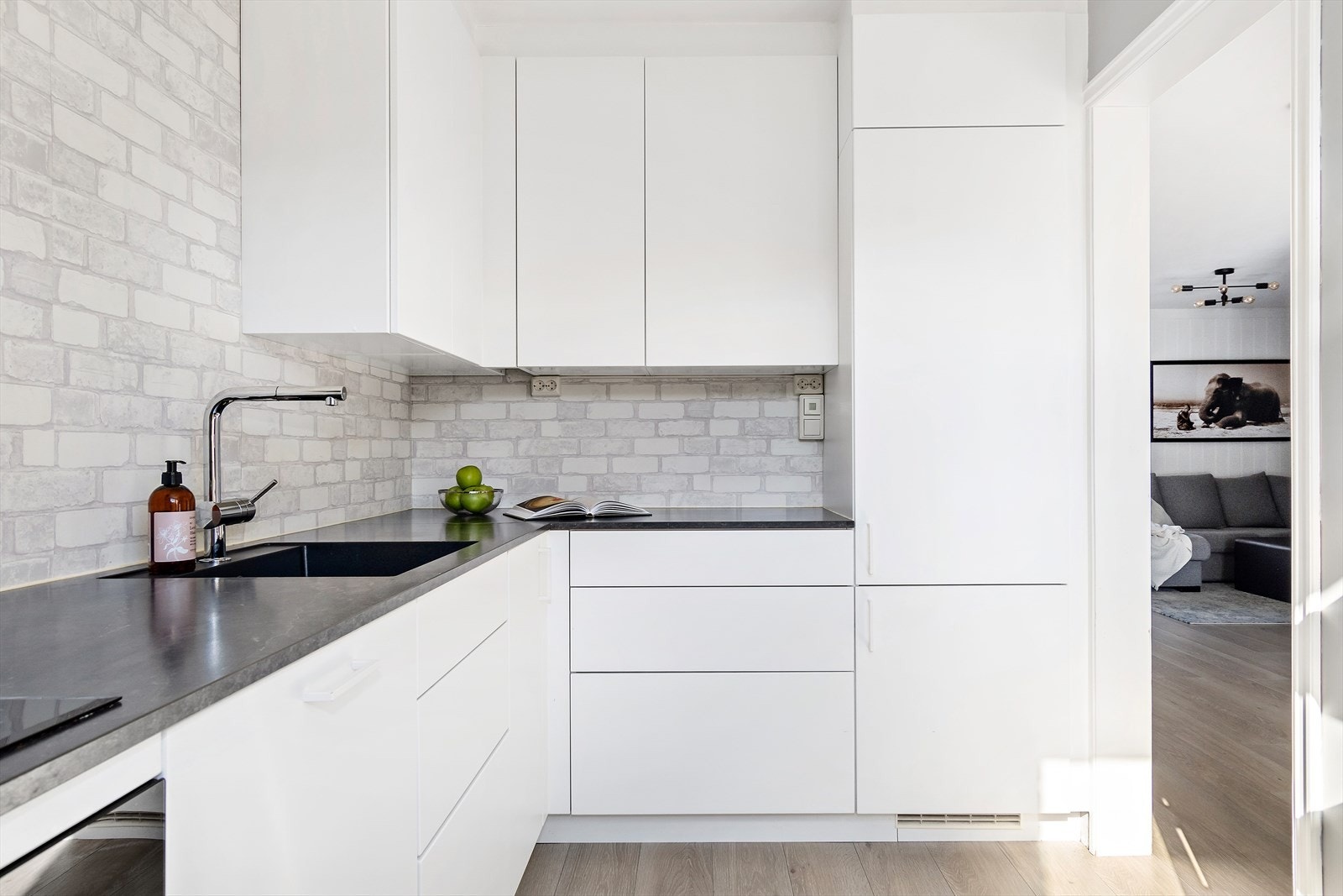 Moderne kjøkkeninnredning fra Kvikk med glatte fronter og benkeplate i laminat med nedfelt oppvaskkum. Galleribilde