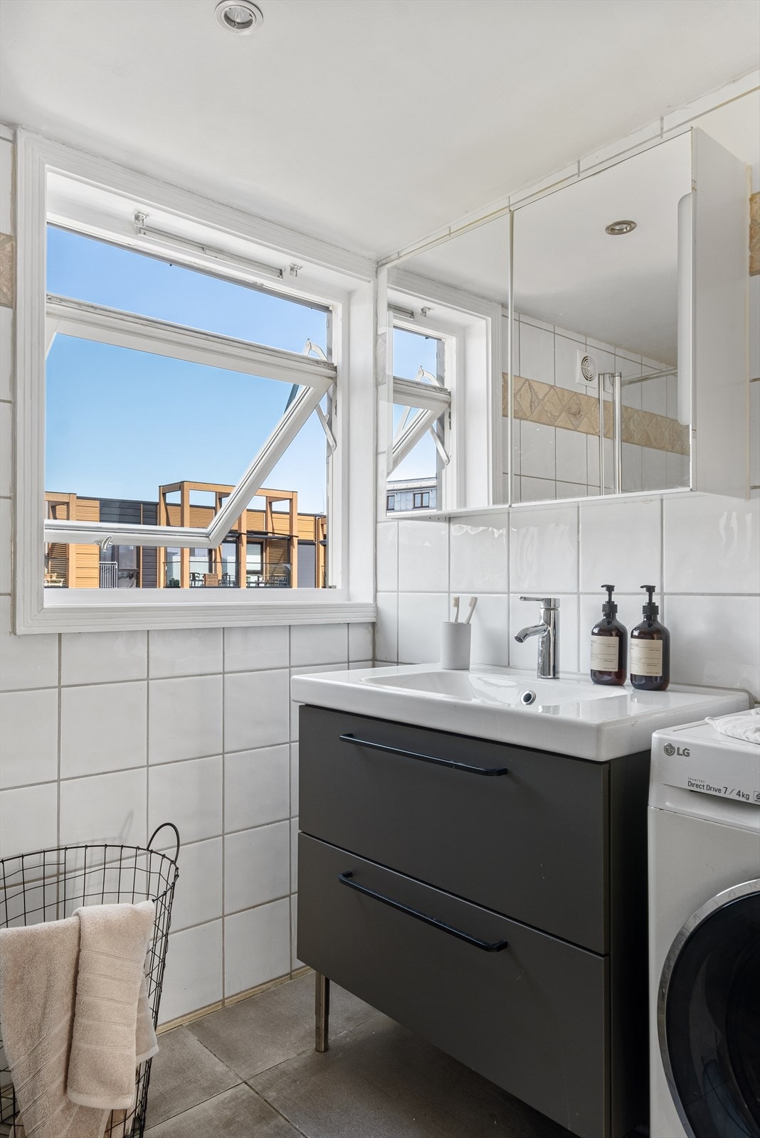 Baderomsinnredningen består av badekar, dusjhjørne med svingbare dusjdører, vegghengt toalett, servantinnredning med ovenpåliggende servant og vegghengt speil. Galleribilde