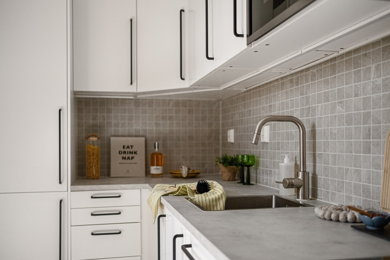 Kjøkkeninnredningen består av hvite, glatte fronter. Laminat benkeplate med nedfelt vaskekum. Galleribilde