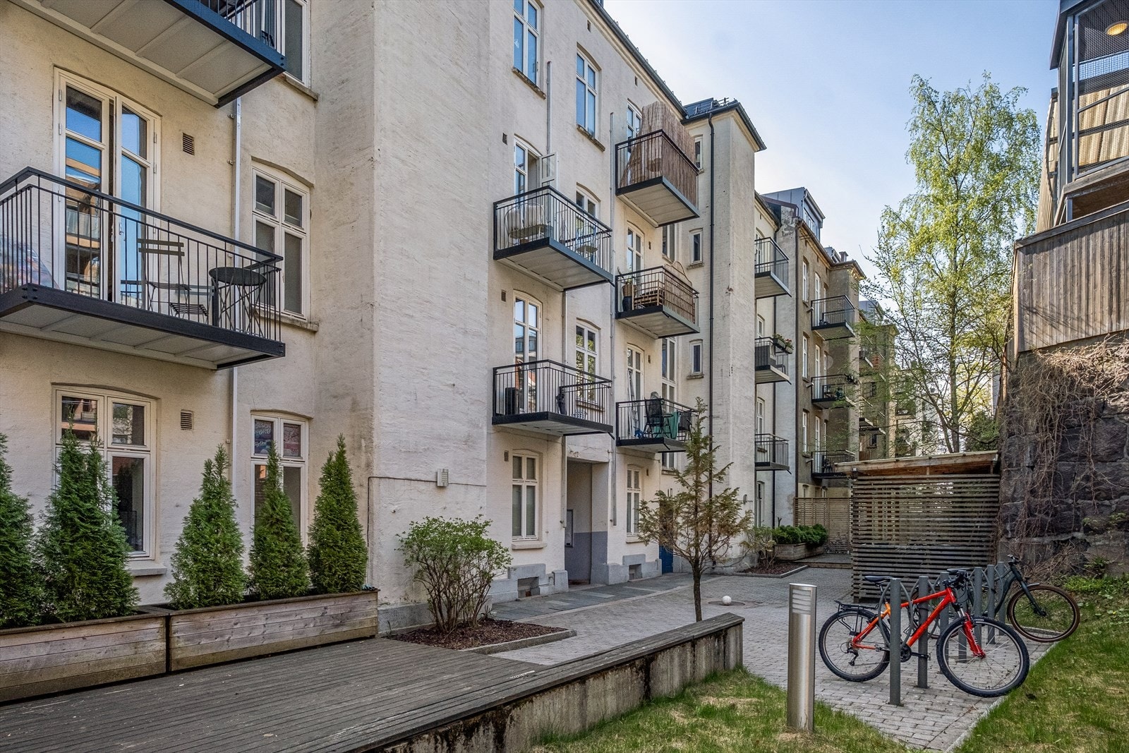 Sameiets hyggelige, felles bakgård er opparbeidet med sykkelstativ, beplantning og belegningsstein. Galleribilde