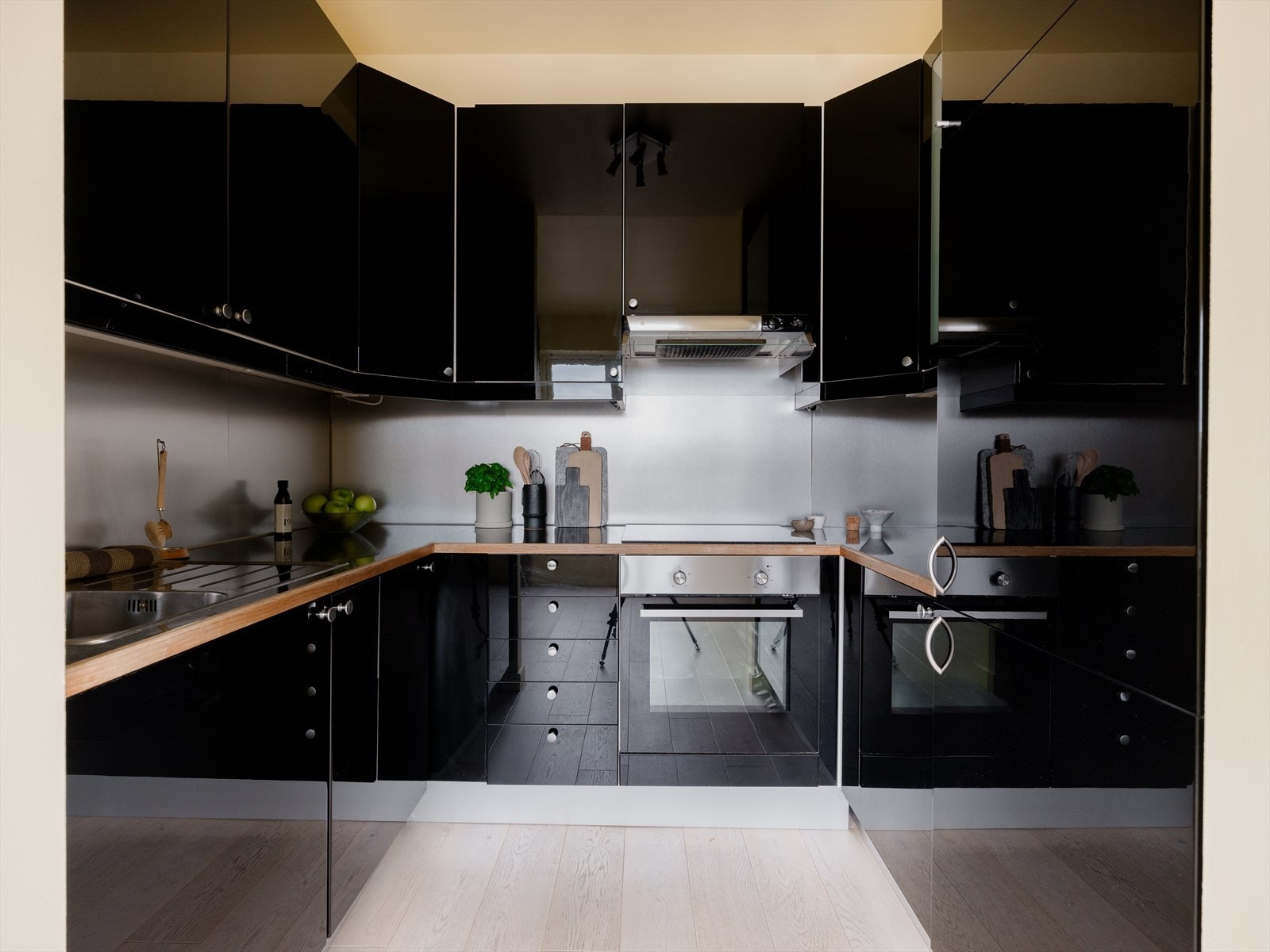 Kjøkkenet er innredet med mørkfolierte, slette fronter og to vitrinefronter fra IKEA. Komfyr med induksjons platetopp, oppvaskmaskin (2019) og kjøl/frys er integrert i innredningen. Galleribilde