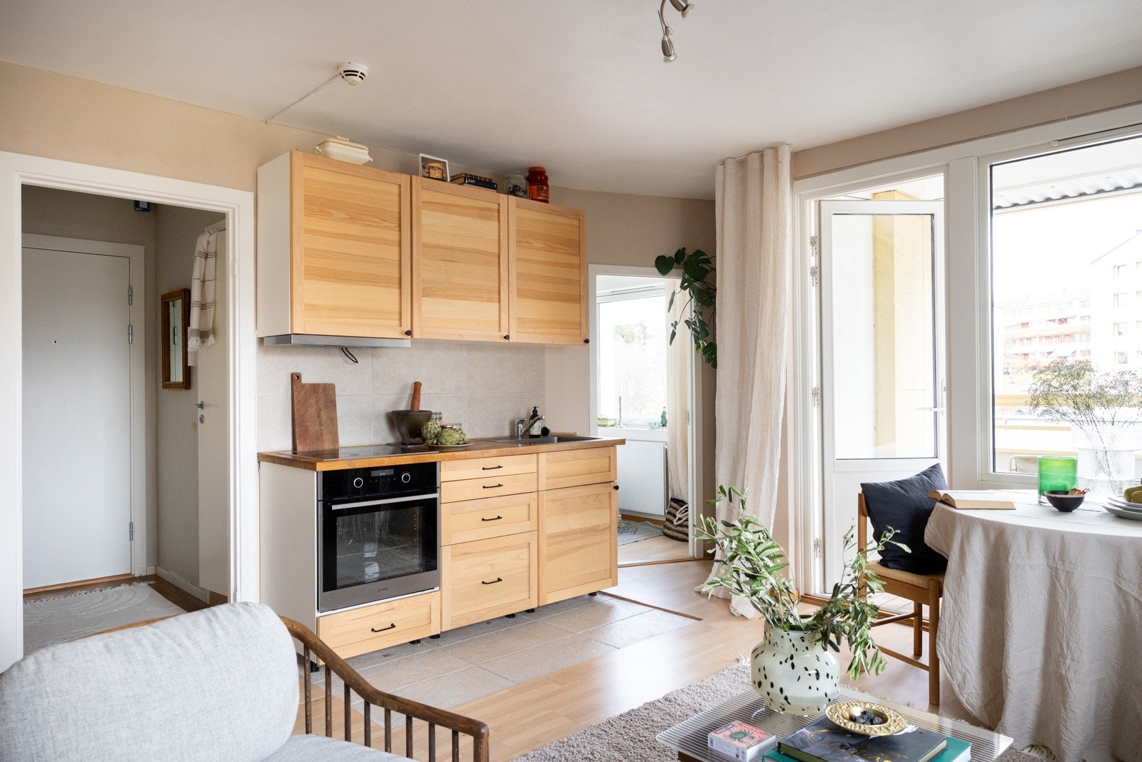 Flott kjøkken fra Ikea med profilerte fronter i tre og stor benkeplate av laminat. Galleribilde