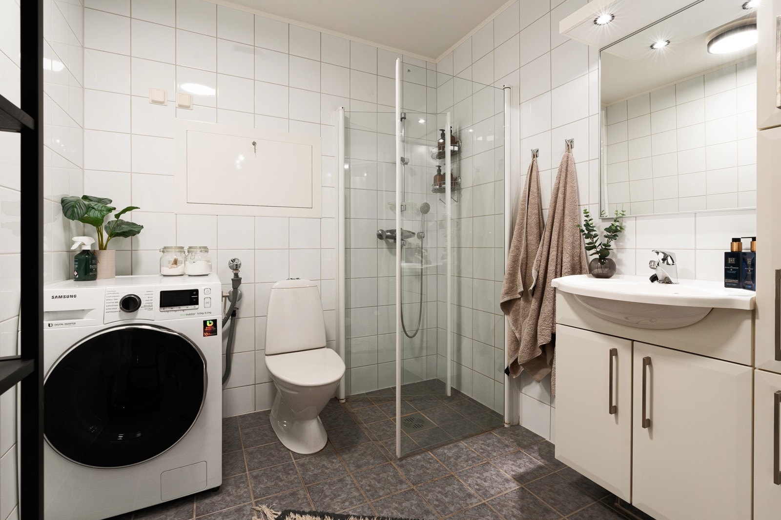 Flislagt bad/vaskerom med gulvvarme, wc og dusjhjørne med innfellbare glassdører Galleribilde