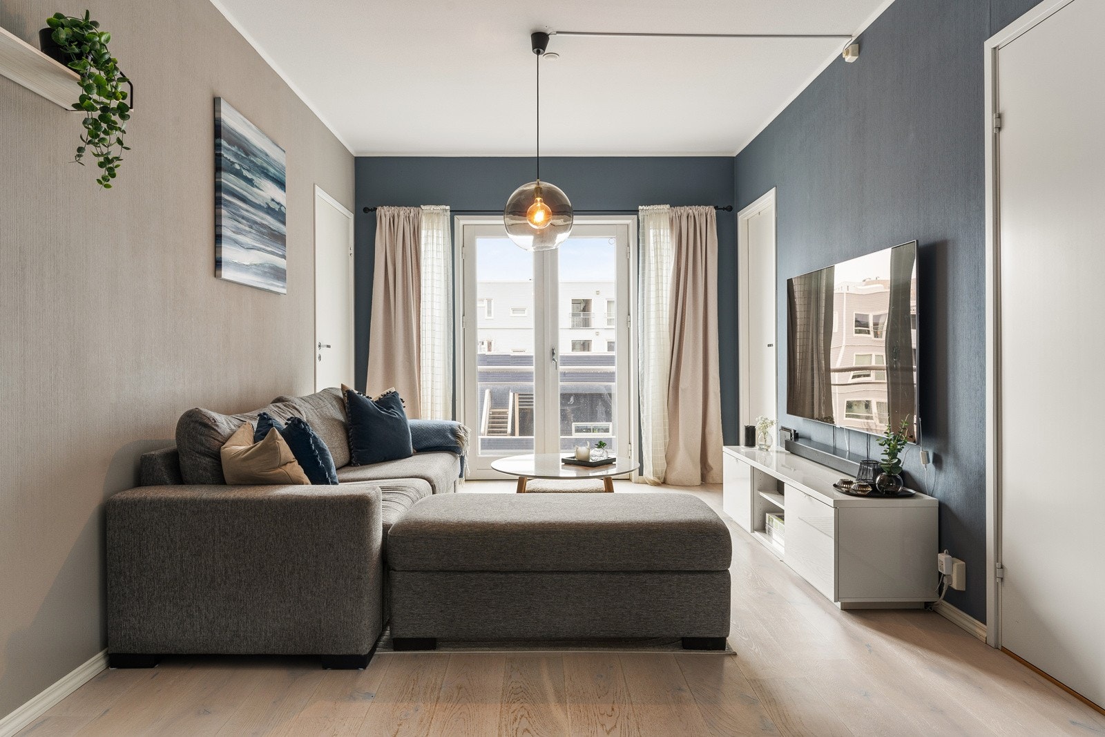 Koselig stue med11- stavs parkett, fransk balkong og store vindusflater som gir rikelig med naturlig lysinnslipp Galleribilde