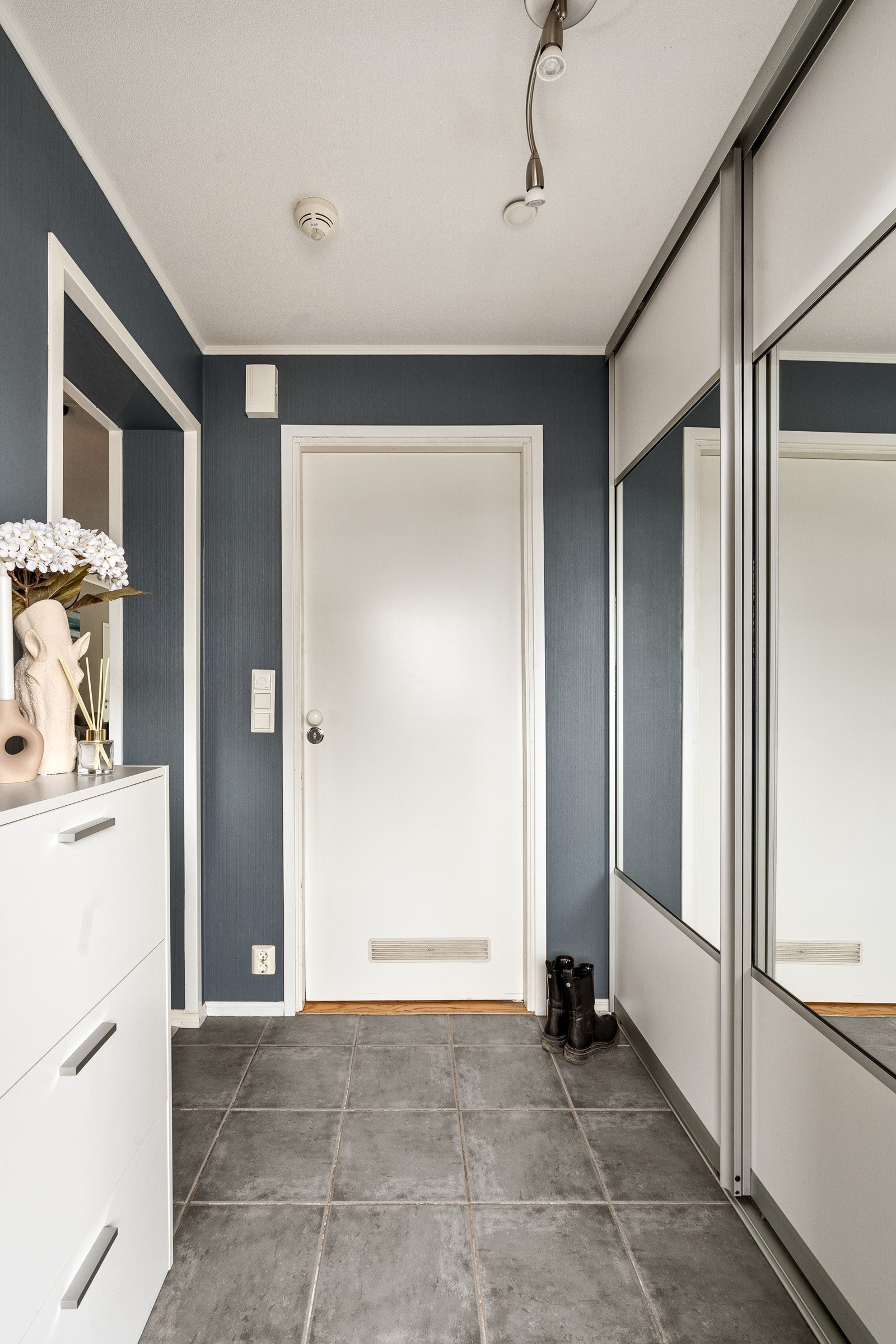 Innbydende entré med fliser på gulv, vannbåren gulvvarme og praktisk skyvedørsgarderobe Galleribilde