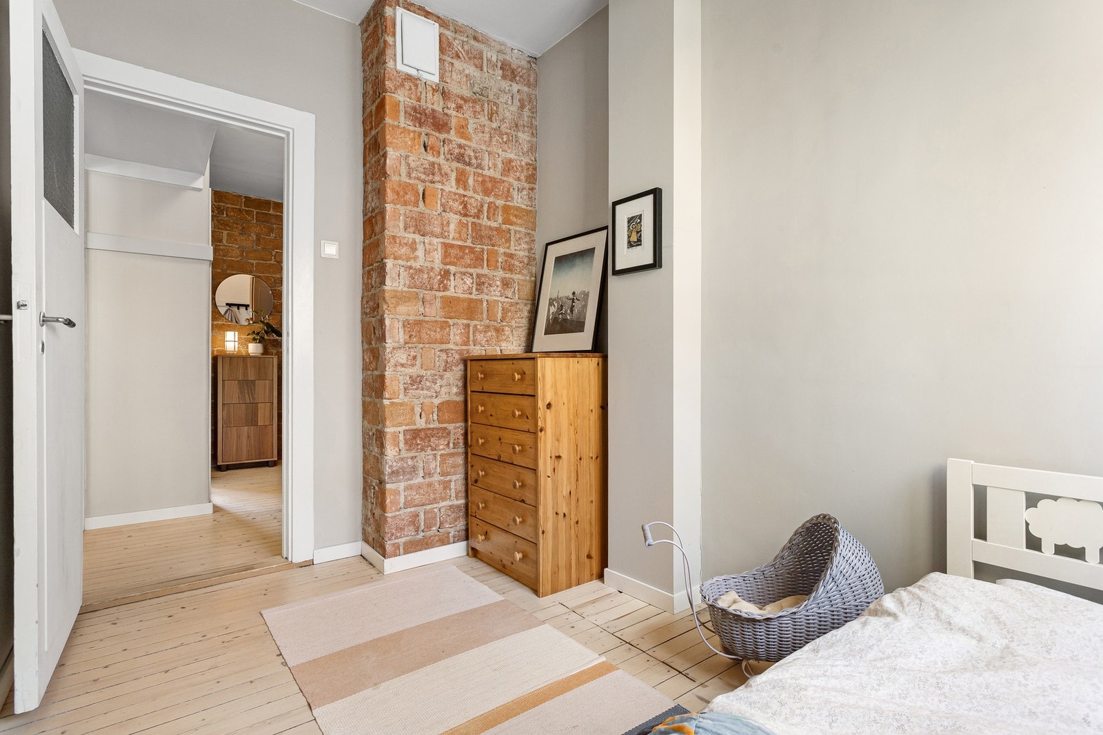 Eksponert teglsteinsvegg gir et rustikt preg som matcher godt med resten av stilen i leiligheten Galleribilde