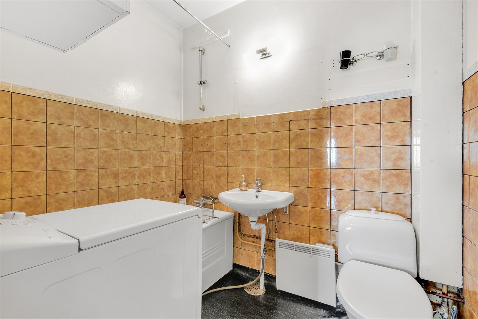 Baderom med fliselagt design og praktisk vaskerom integrering. Galleribilde