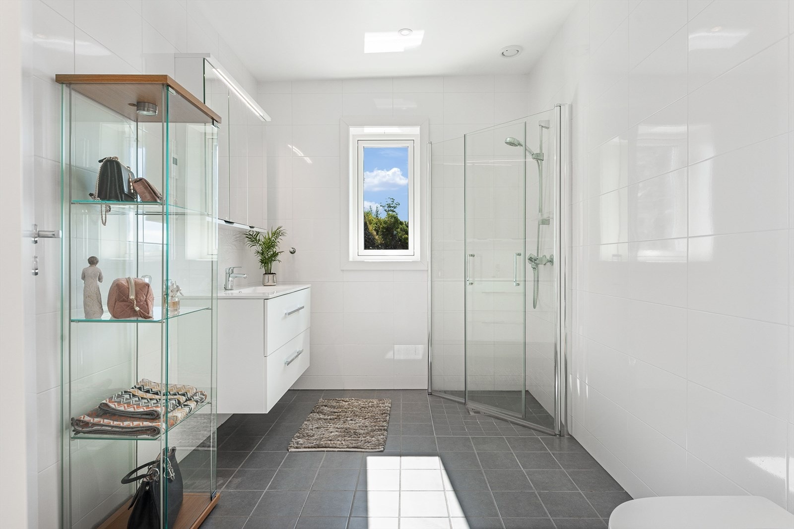 Romslig og tidsriktig baderom med pene flislagte vegger og gulv, med vannbåren varme Galleribilde