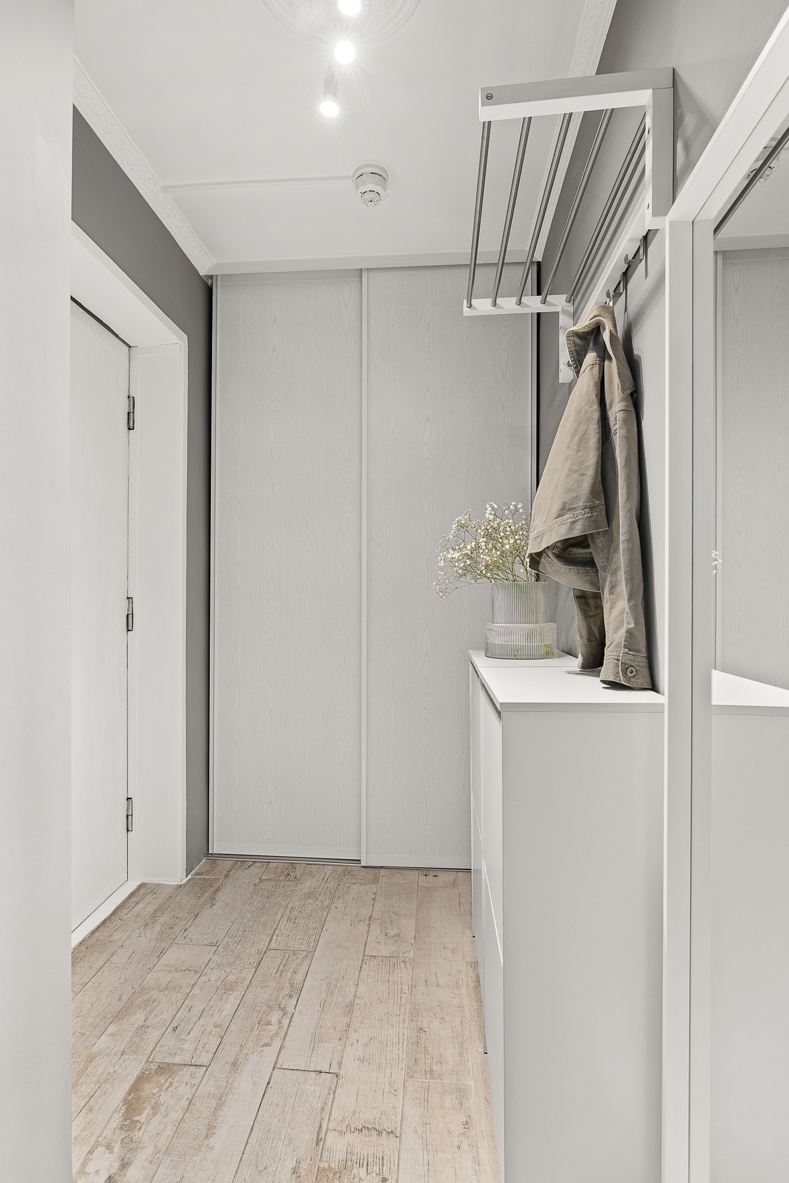 Entré med skyvedørsgaderobe. Opplegg for vaskemaskin er etablert bak skyvedørsfronter i entré. Galleribilde