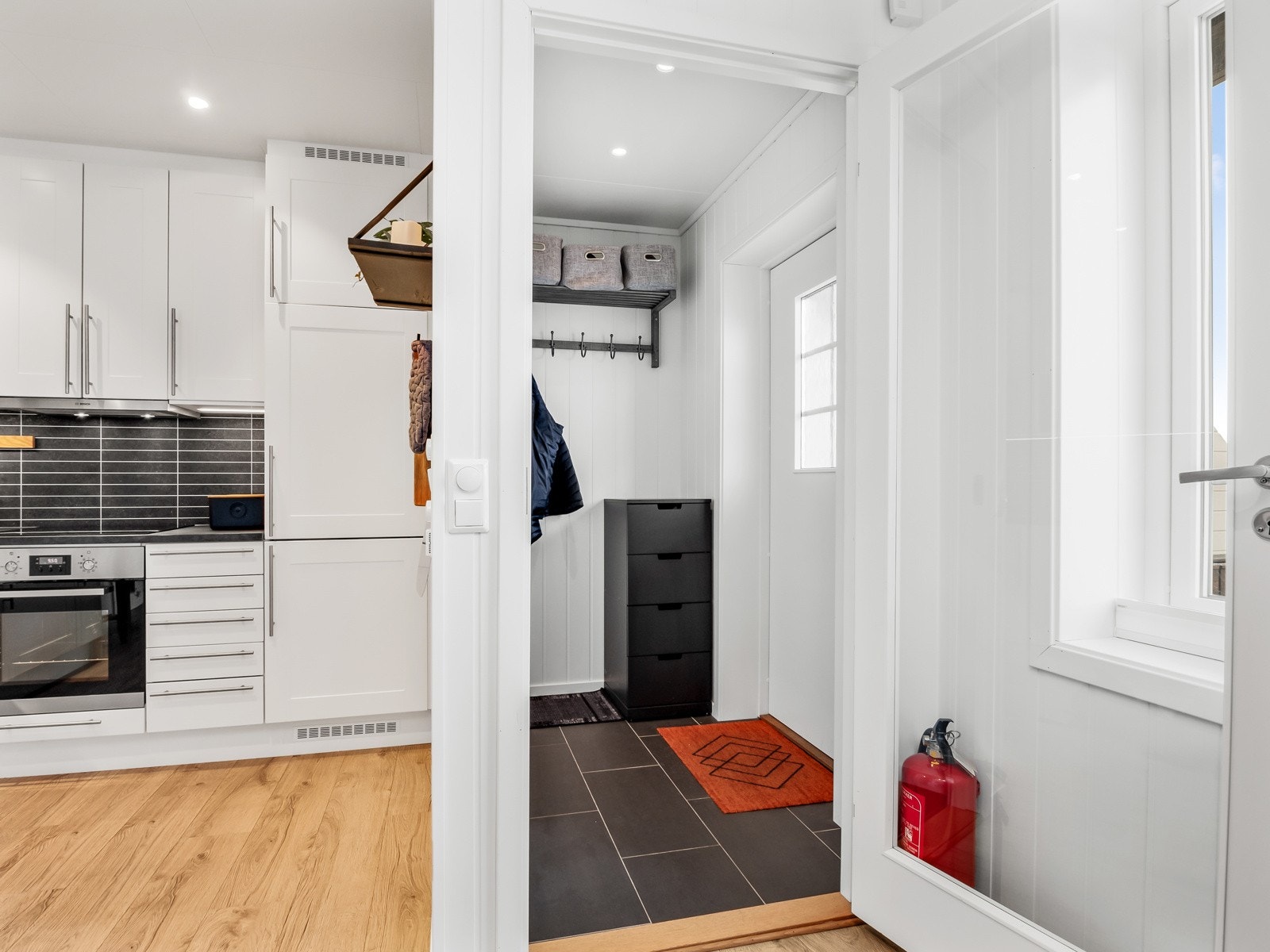 Fra vindfanget kommer man inn i en delvis åpen stue/kjøkkenløsning Galleribilde