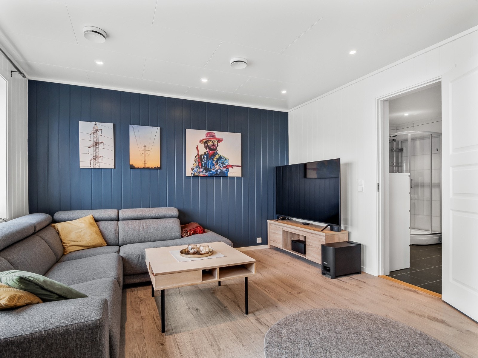 Stuen er lys og koselig, og med en pen fondvegg som kontrast Galleribilde