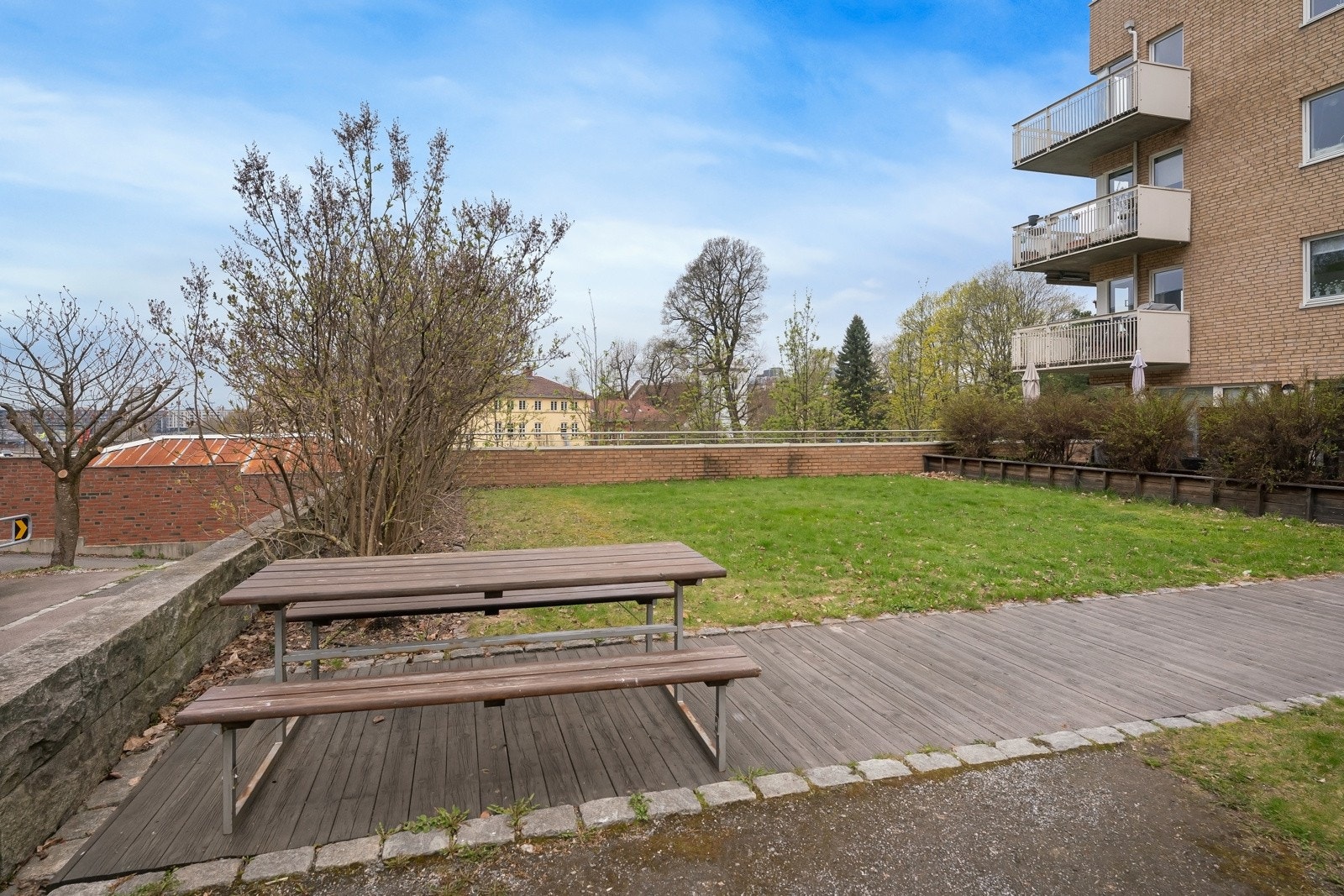 Pent opparbeidede uteområder med felleshage, benker og beplantning. Galleribilde