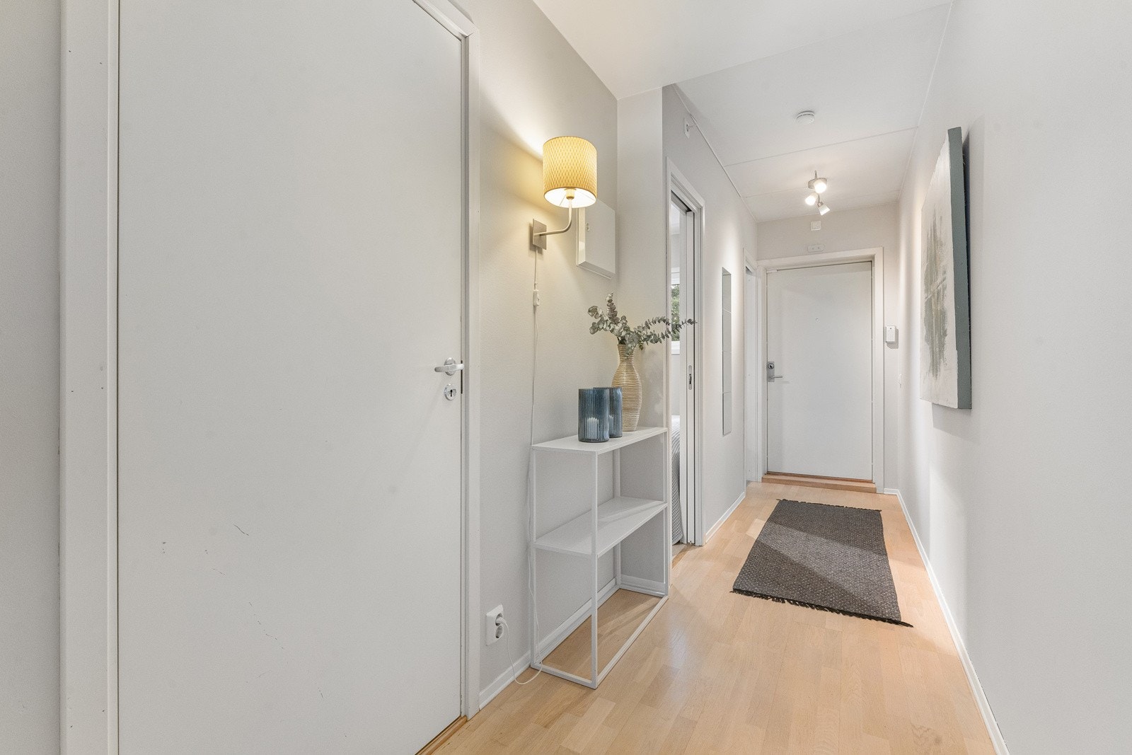 Lys entré som gir et flott førsteinntrykk av leiligheten med hvitmalte vegger, parkettgulv og spotlights i himling. Galleribilde